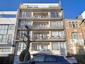 Résidence moderne avec balcons façade beige et parking dans un quartier mixte traditionnel et contemporain