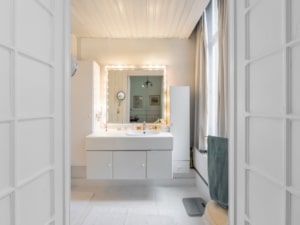 Salle de bain moderne et lumineuse avec meuble épuré grand miroir éclairé espace de rangement