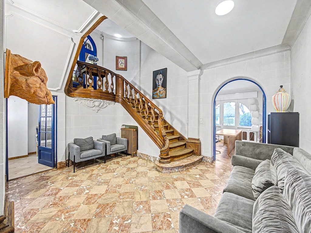 Lichte woonkamer met houten trap, grijze bank en panoramisch uitzicht op Ontario.