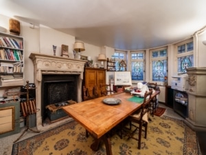 Salon chaleureux avec vitraux colorés cheminée ornée mobilier en bois et ambiance intemporelle