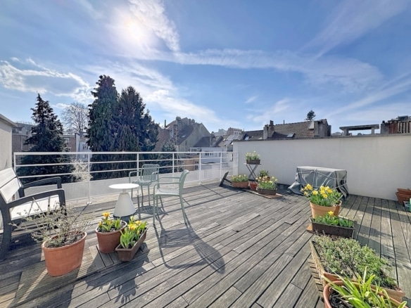 Urban wooden terrace with furniture, plants, residential view in Woluwe-Saint-Lambert.
