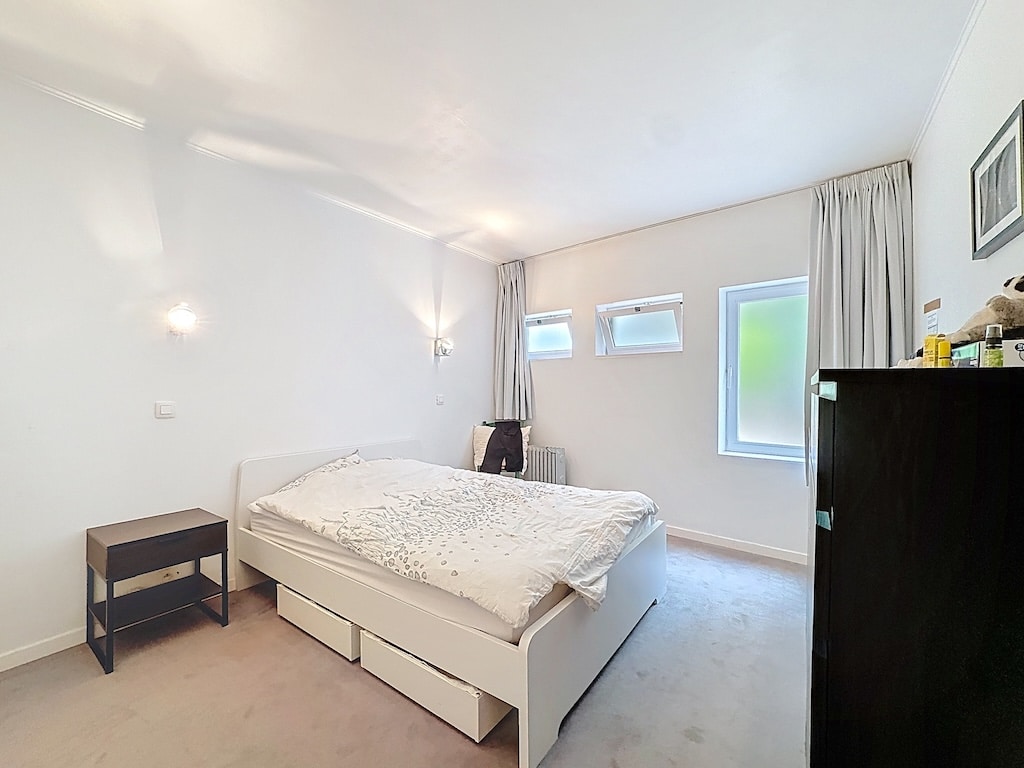 Lichtgevende minimalistische kamer in Parijs met ononderbroken uitzicht en verfijnde inrichting.