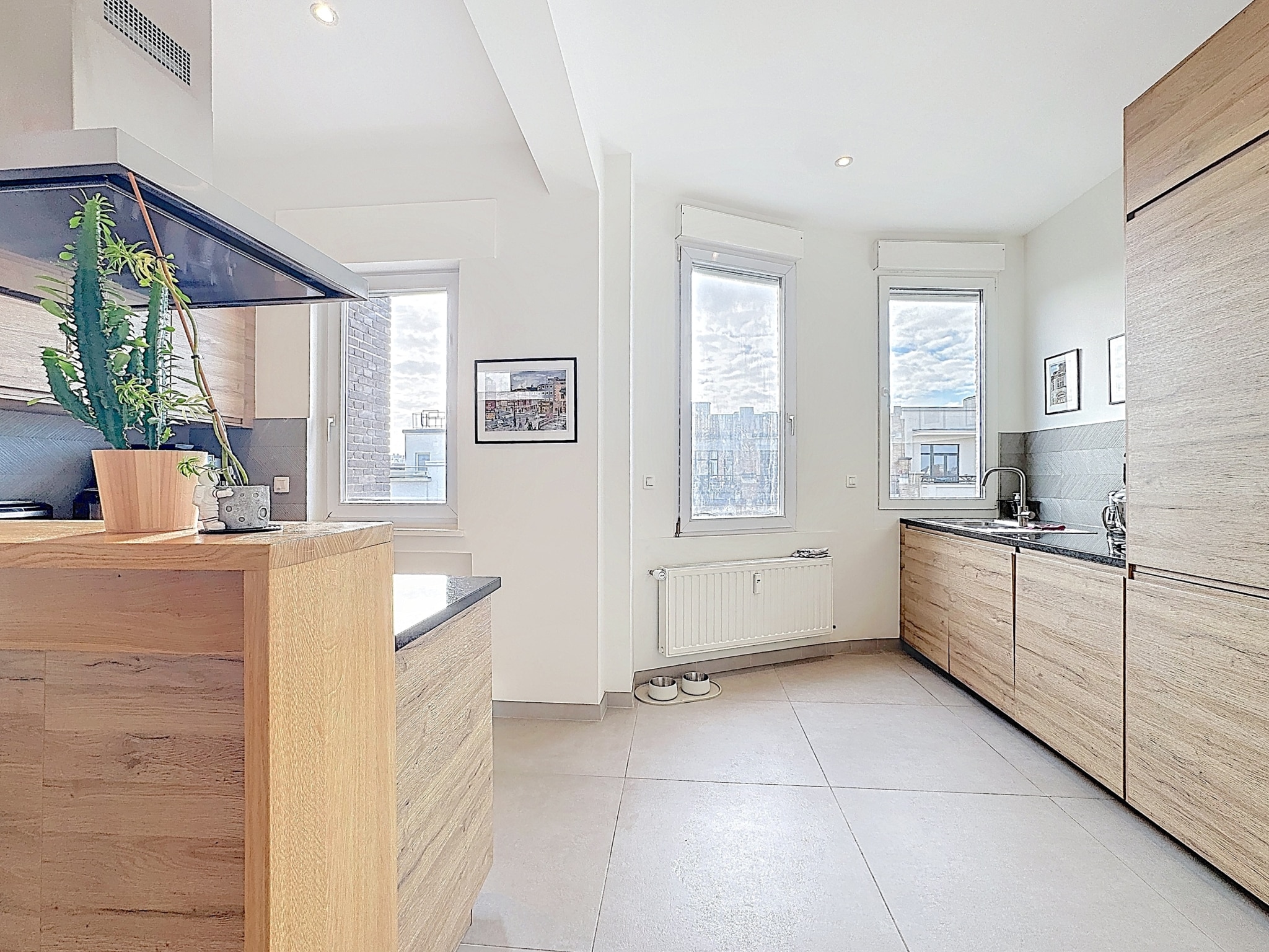 Lichte moderne keuken - U Vastgoedkantoor Lichte moderne houten keuken met centraal eiland en grote ramen