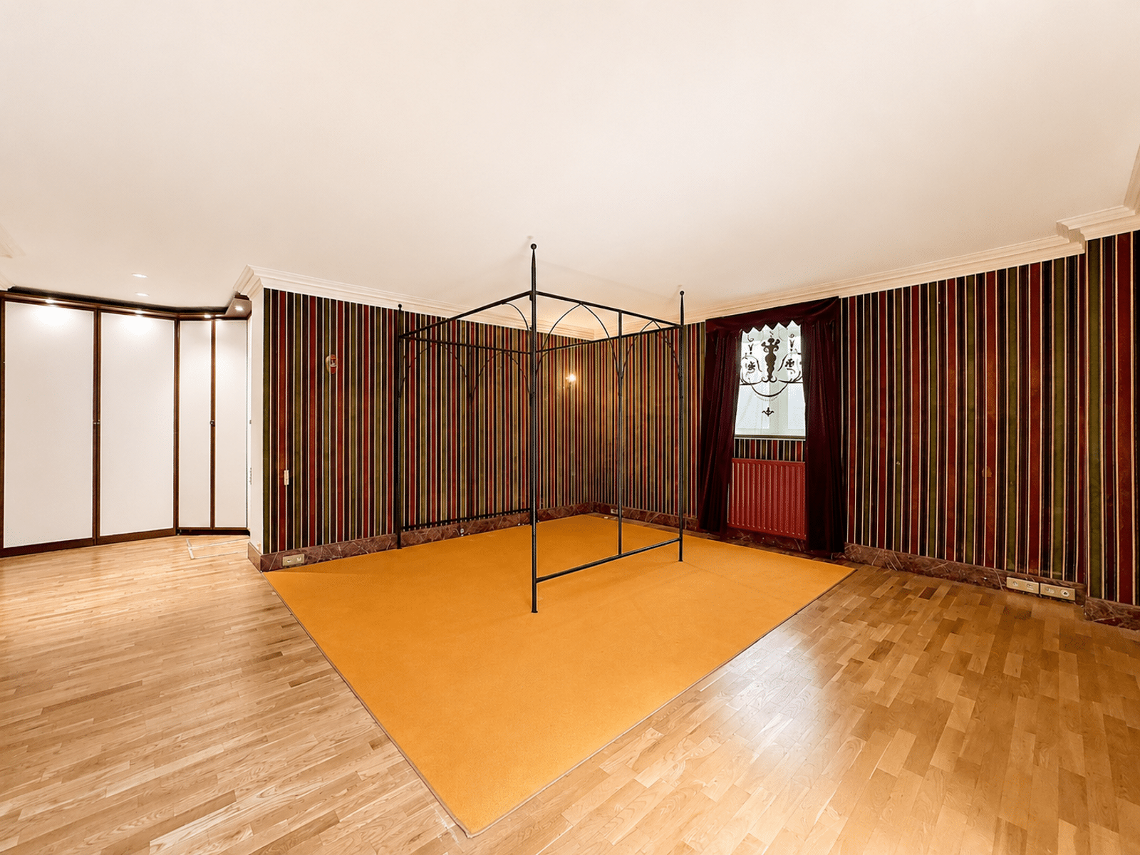 Chambre Avec Lit à Baldaquin Noir - You Real Estate Agency Large bedroom with black four-poster bed, light parquet and striped wallpaper