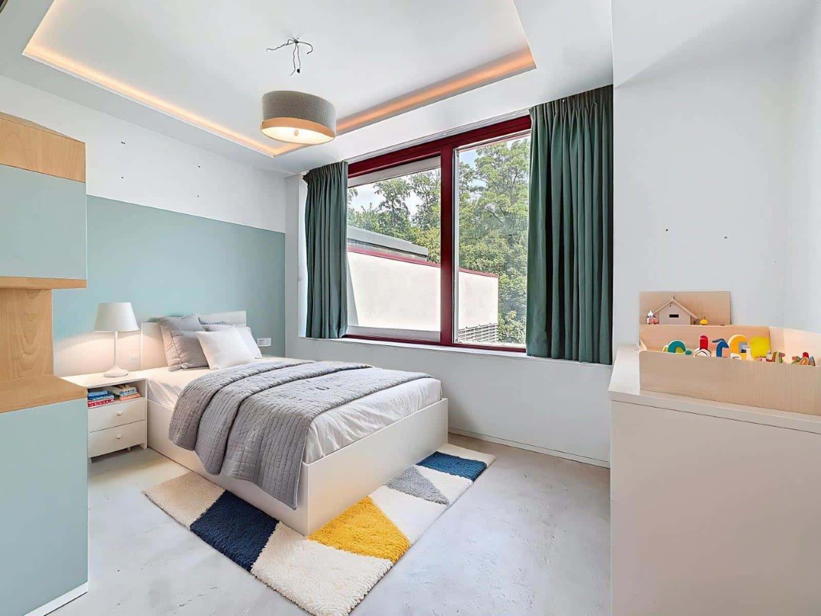 Chambre Moderne avec Grande Fenêtre – You Real Estate Agency Chambre moderne lumineuse avec lit simple, grande fenêtre, rideaux verts et rangements intégrés