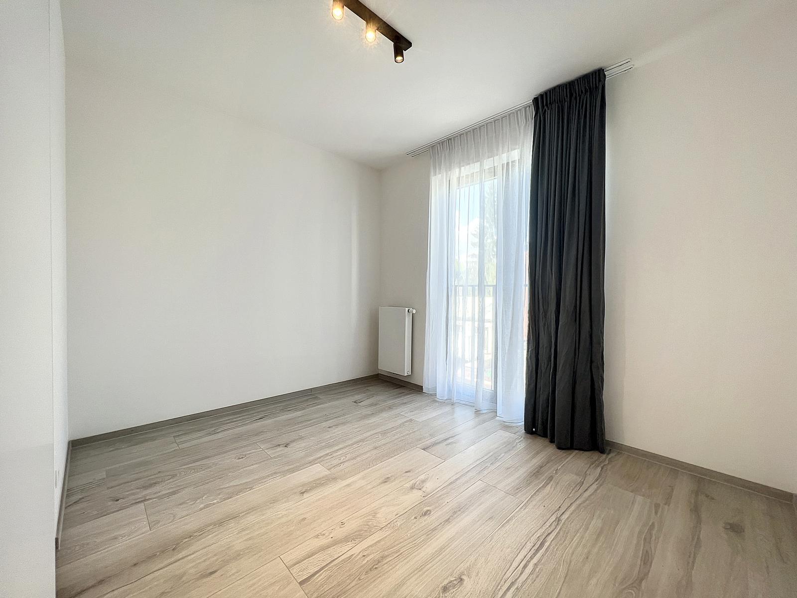 Chambre Lumineuse avec Grande Fenêtre – You Real Estate Agency Chambre lumineuse vide avec parquet, grande fenêtre et rideaux foncés