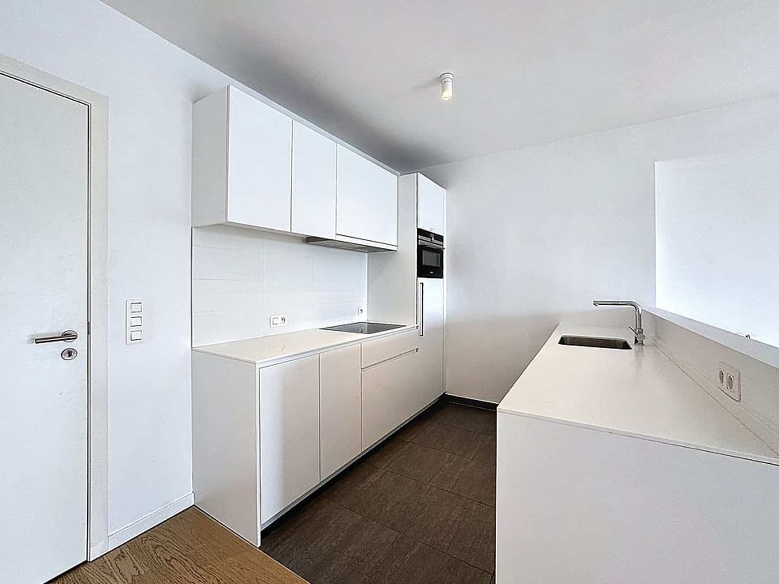 Sleek white kitchen - You Real Estate Agency Modern white kitchen with sink, hob and built-in oven
