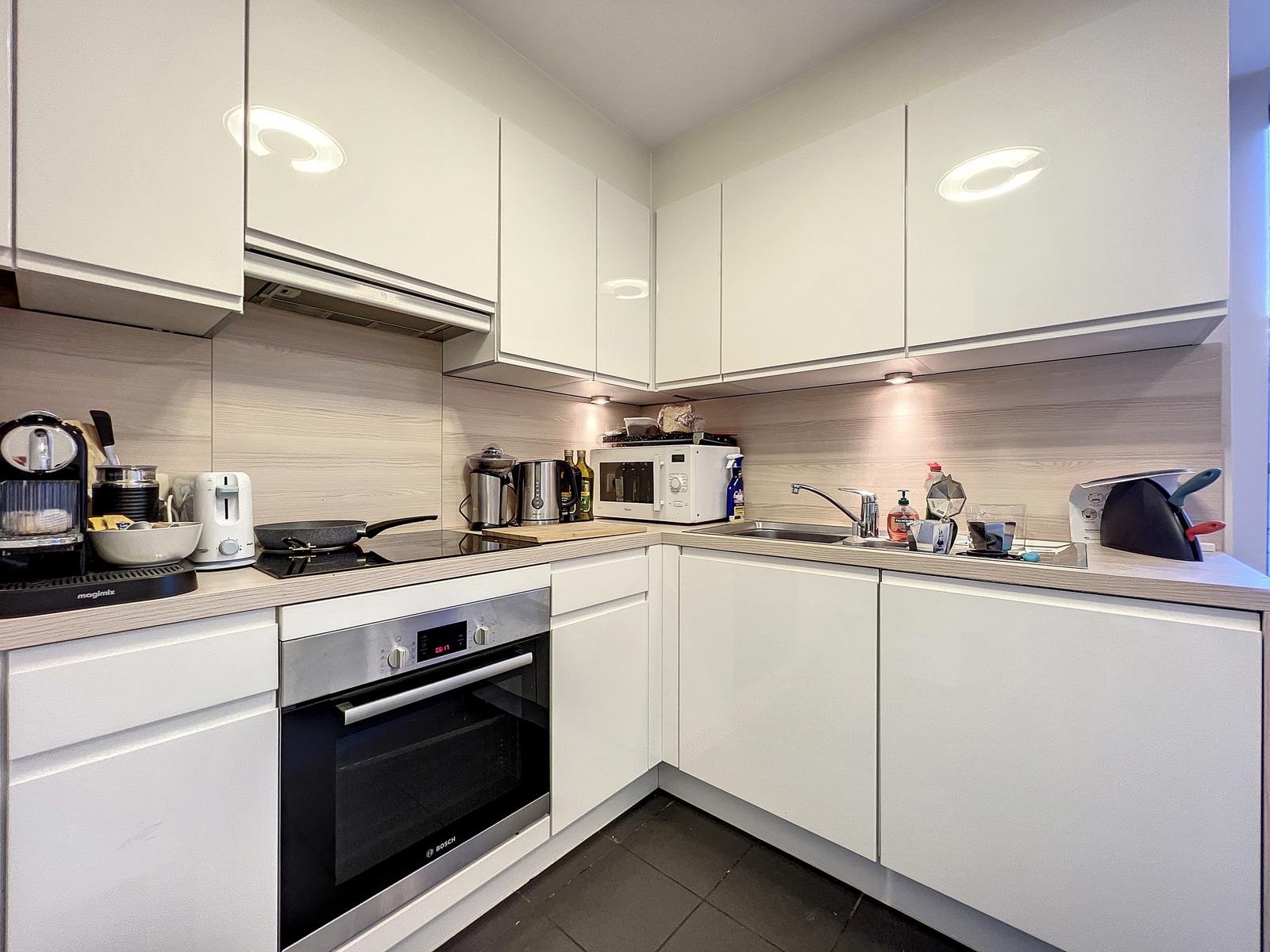 Cuisine Moderne Équipée – You Real Estate Agency Cuisine équipée moderne en L, meubles blancs laqués et crédence effet bois