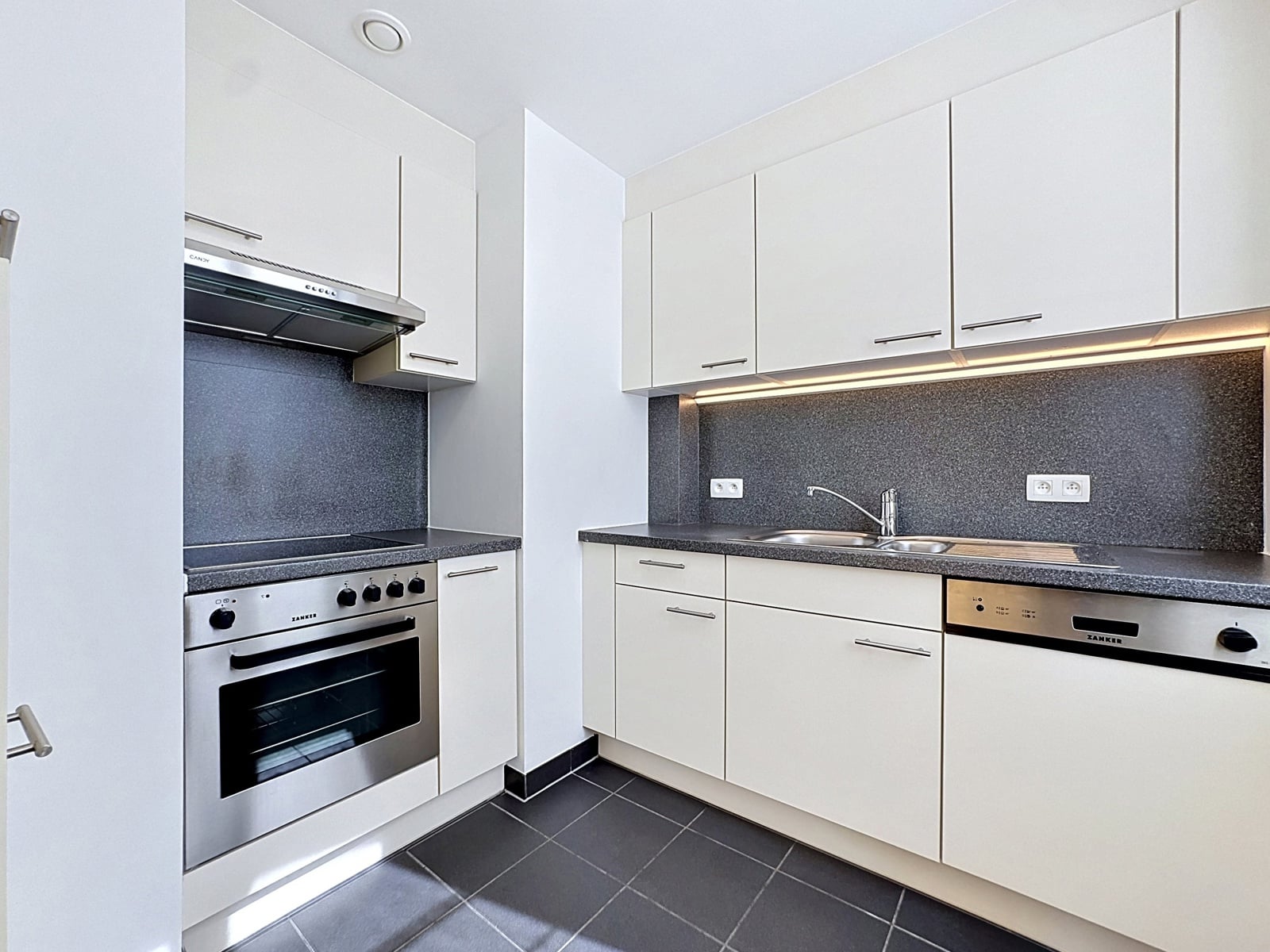 Modern white fitted kitchen - You Real Estate Agency Modern white fitted kitchen with integrated oven, double sink and grey worktop