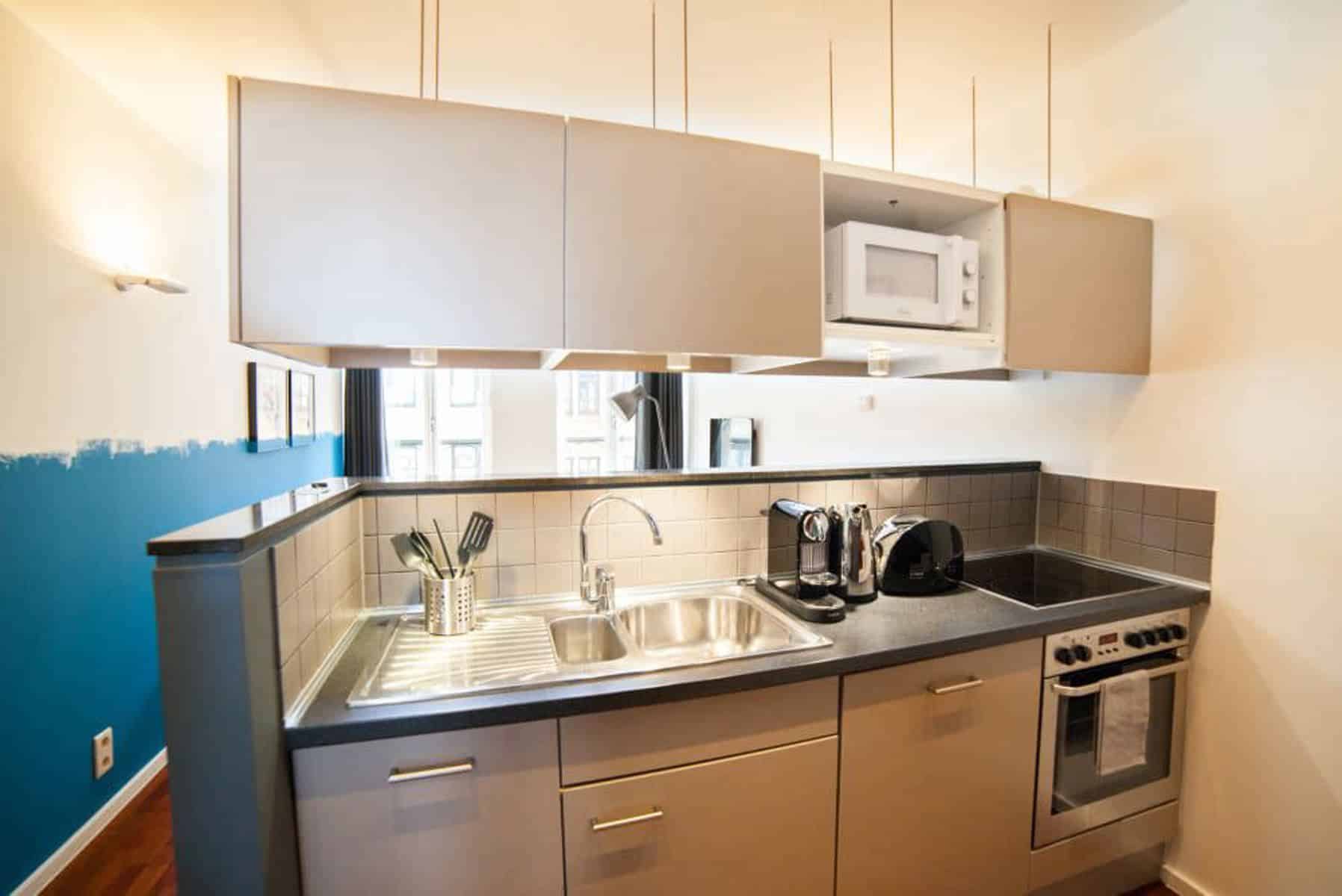 Cuisine Équipée Moderne Ouverte – You Real Estate Agency Cuisine équipée moderne ouverte sur séjour lumineux, meubles taupe et électroménager intégré