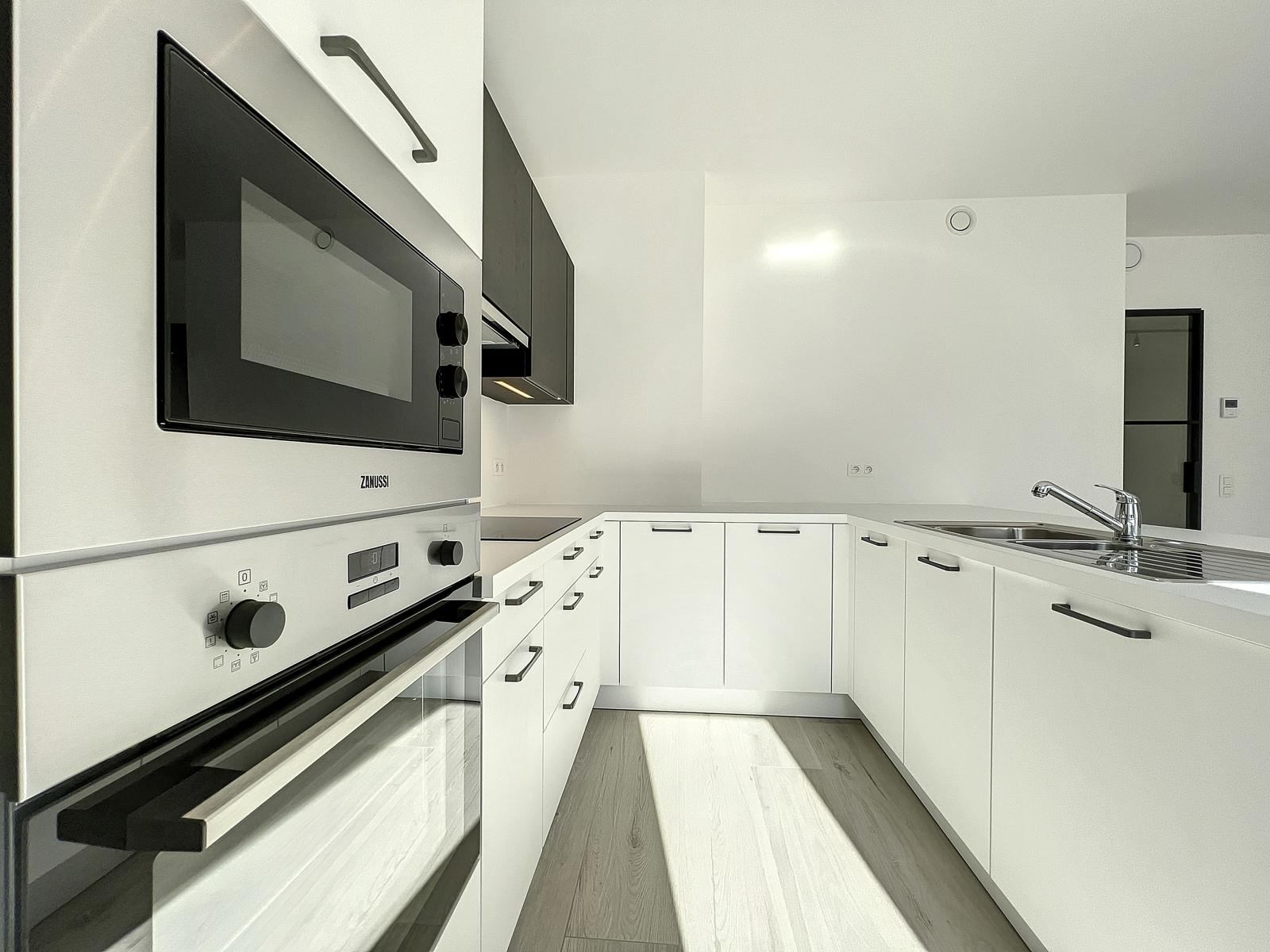 Cuisine Moderne Équipée et Lumineuse – You Real Estate Agency Cuisine équipée blanche et lumineuse avec four intégré, plaque et évier inox