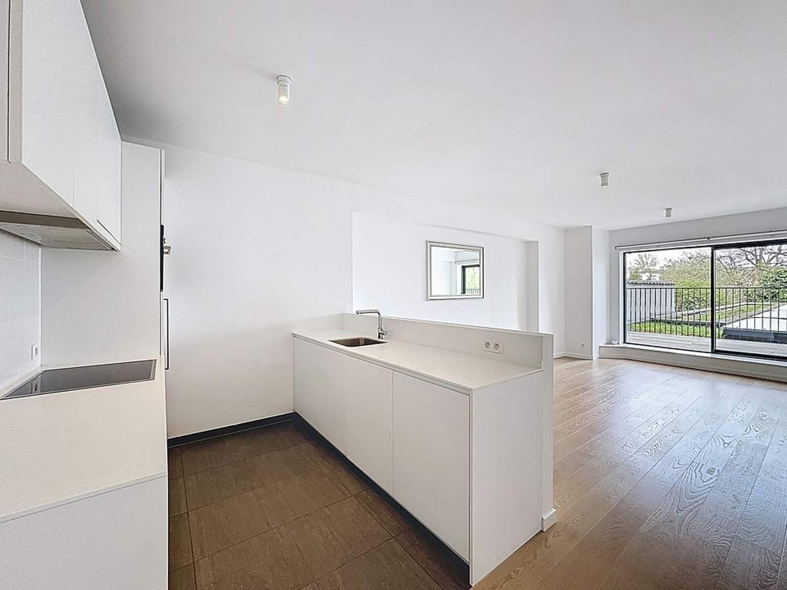 Open kitchen with living room and terrace - You Real Estate Agency Open kitchen with island, bright living room with parquet flooring and wooded terrace