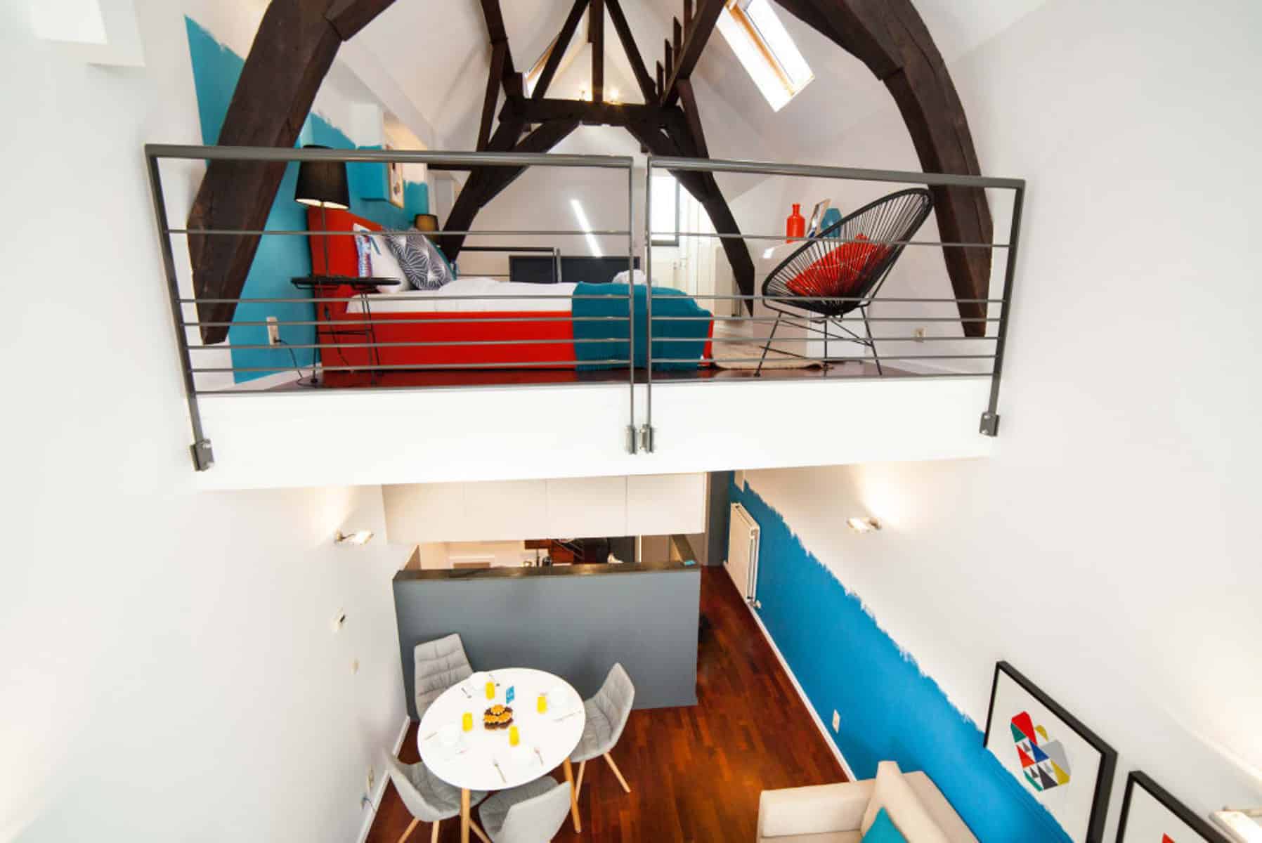 Loft avec Mezzanine et Poutres Apparentes – You Real Estate Agency Loft lumineux avec mezzanine, poutres apparentes, parquet et coin repas moderne
