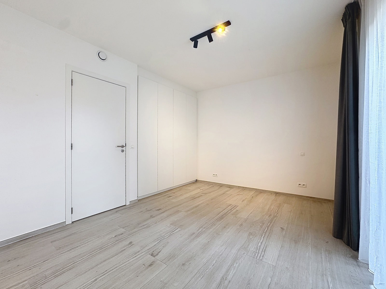 Pièce Moderne avec Placards – You Real Estate Agency Pièce moderne lumineuse avec parquet clair, placards intégrés et grande fenêtre