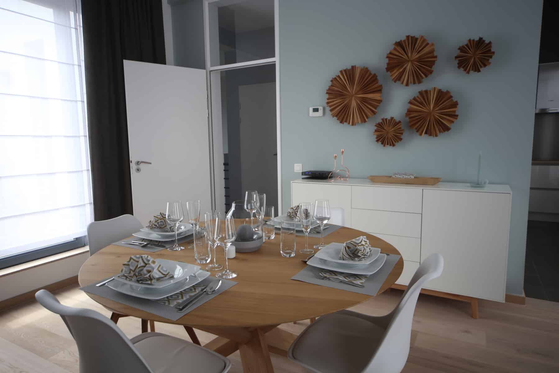 Salle à Manger Moderne et Lumineuse – You Real Estate Agency Salle à manger moderne lumineuse avec table ronde en bois et buffet blanc