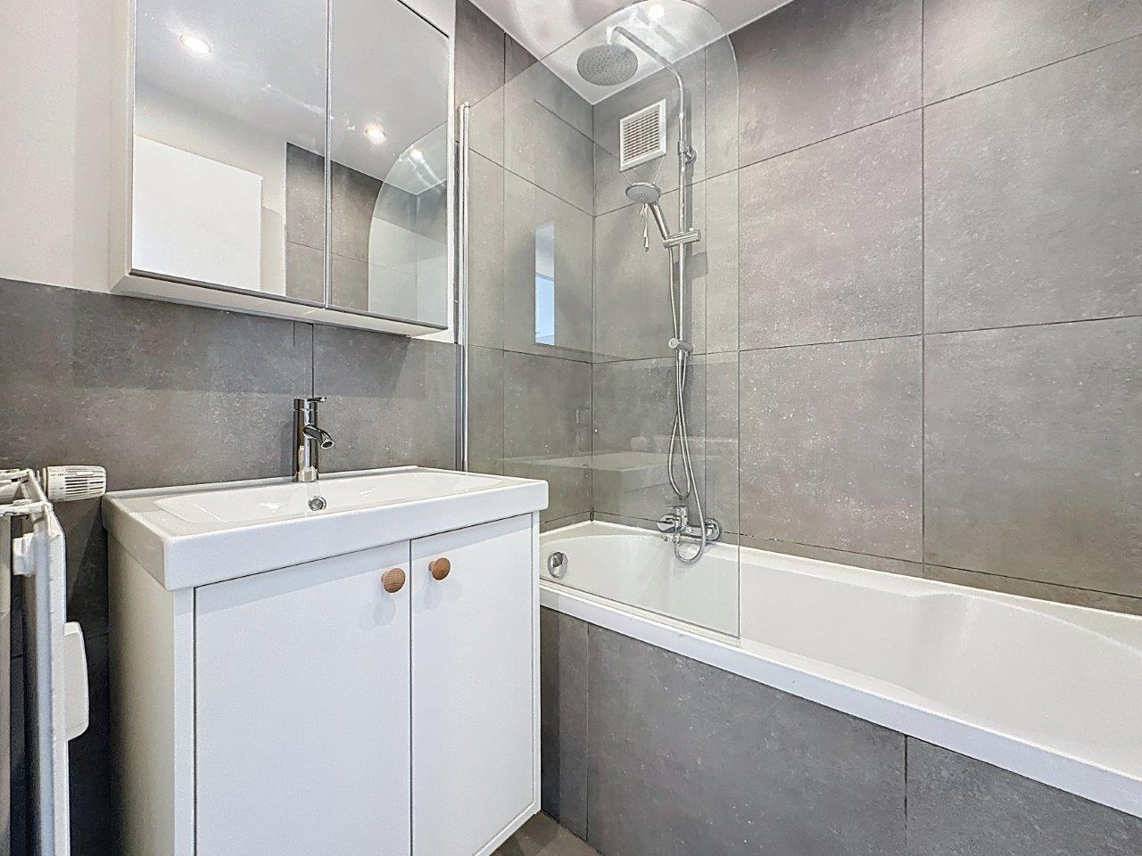 Salle de Bain Moderne avec Baignoire – You Real Estate Agency Salle de bain moderne grise avec baignoire, douche vitrée et meuble vasque blanc