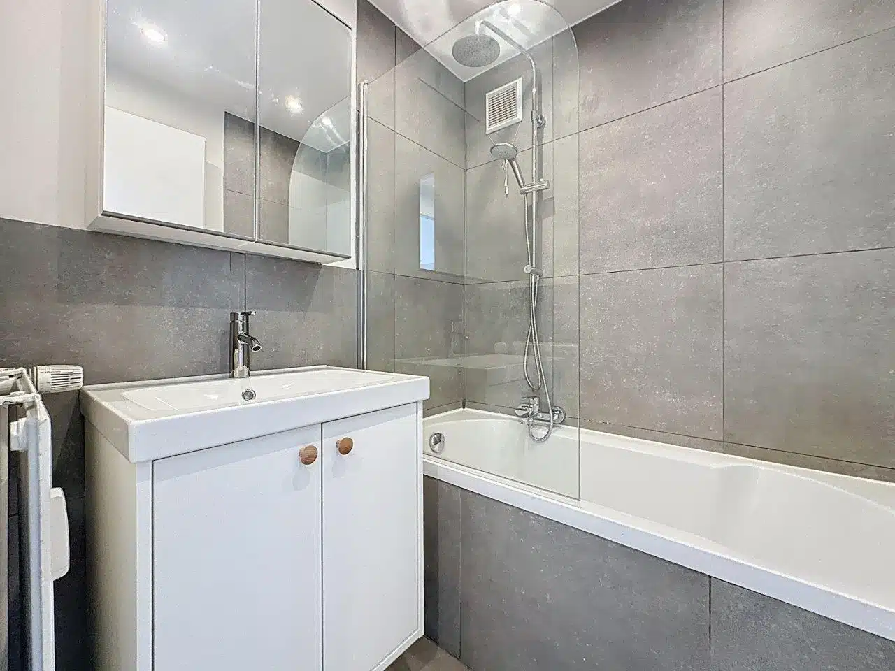 Salle de Bain Moderne Grise - You Real Estate Agency Modern gray bathroom with bathtub and shower in apartment.