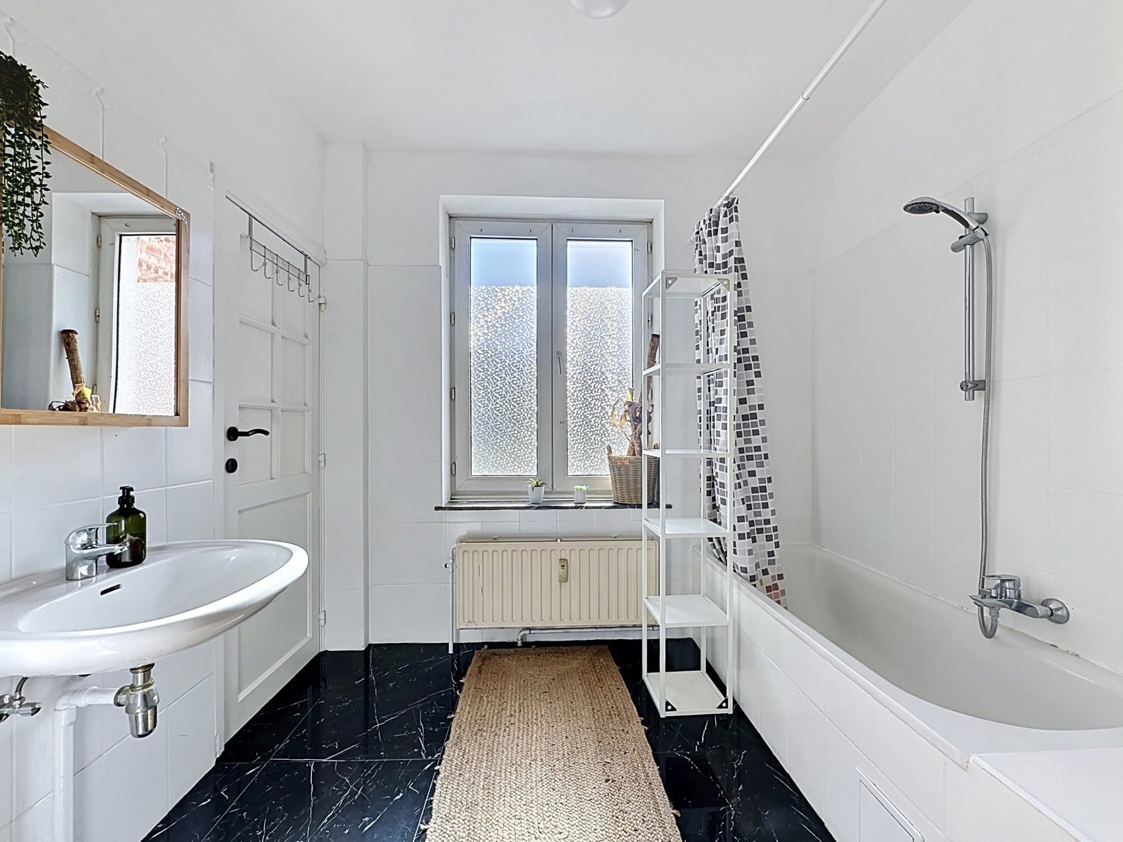 Salle de Bains avec Baignoire – You Real Estate Agency Salle de bains lumineuse avec baignoire, lavabo mural et carrelage noir veiné