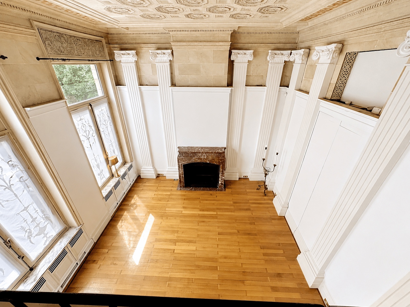 Classic living room with fireplace - You Real Estate Agency Classic, light-filled living room with marble fireplace, white pilasters and coffered ceiling