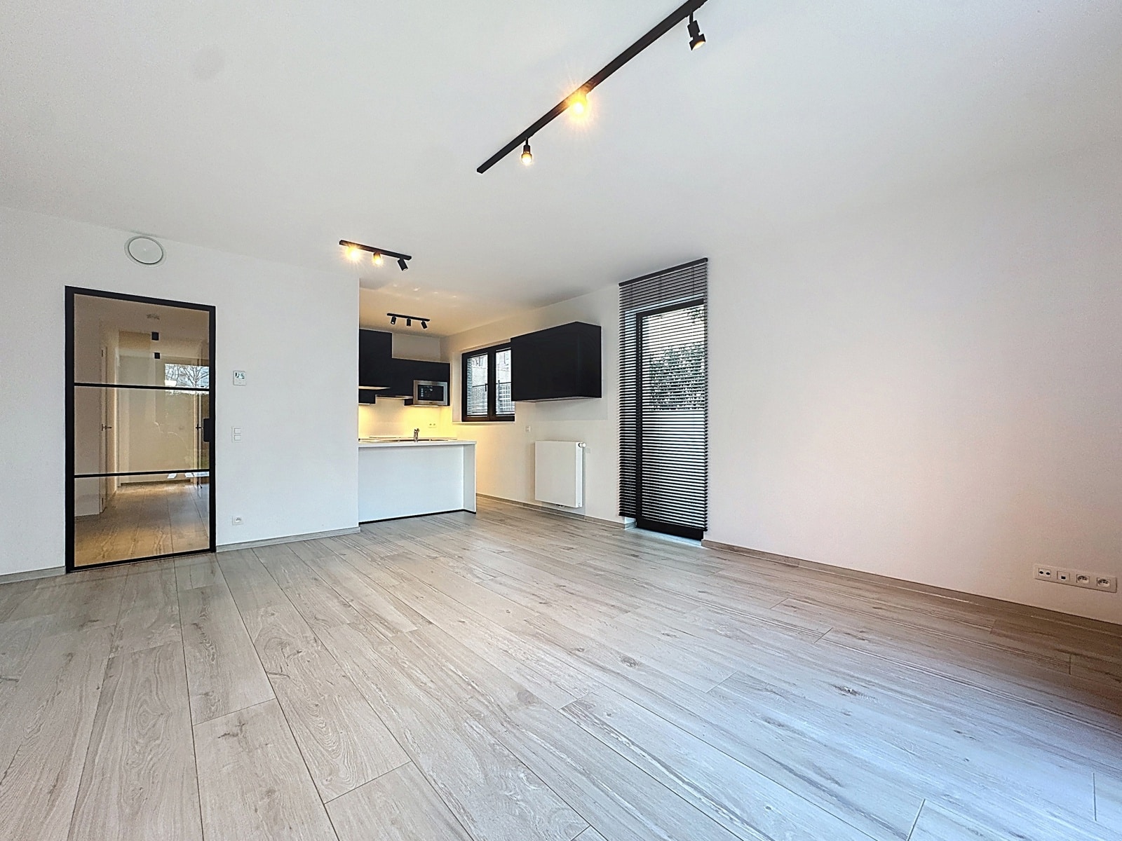 Séjour Rénové avec Cuisine Ouverte – You Real Estate Agency Séjour lumineux rénové avec cuisine ouverte moderne et porte vitrée noire