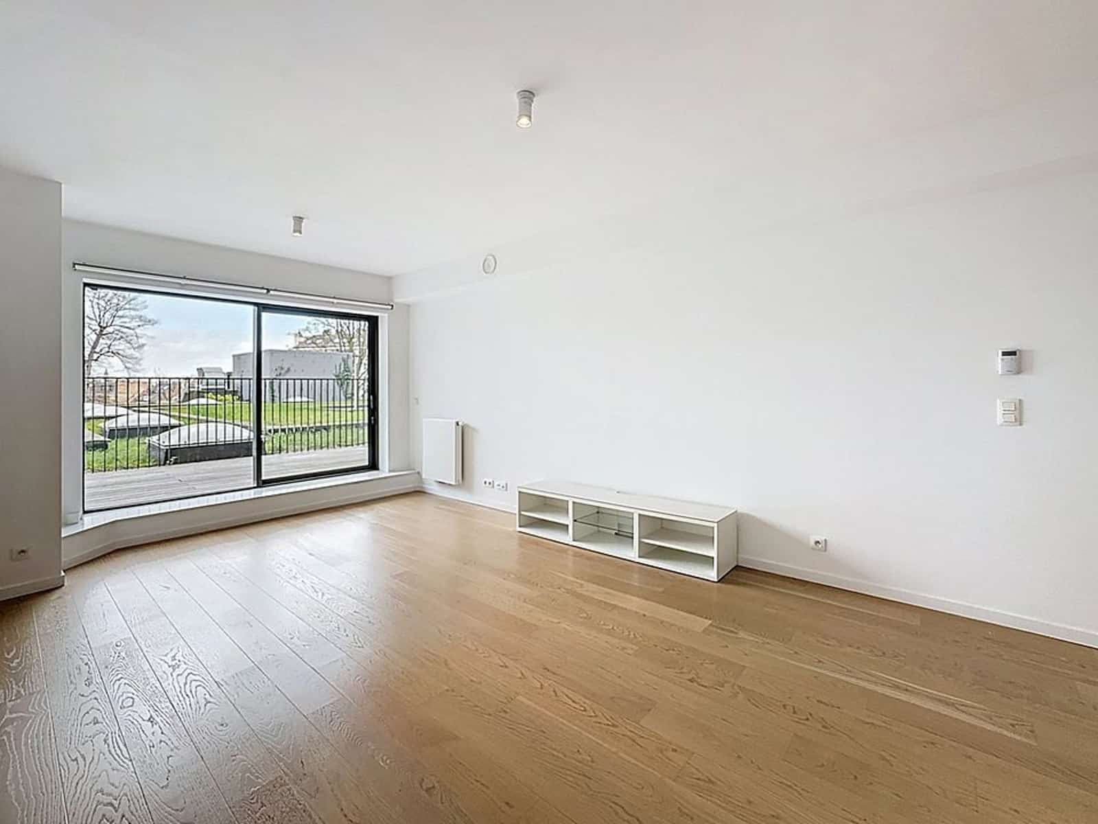 Modern living room with bay window - You Real Estate Agency Bright modern living room with bay window, wooden floor and terrace overlooking the garden