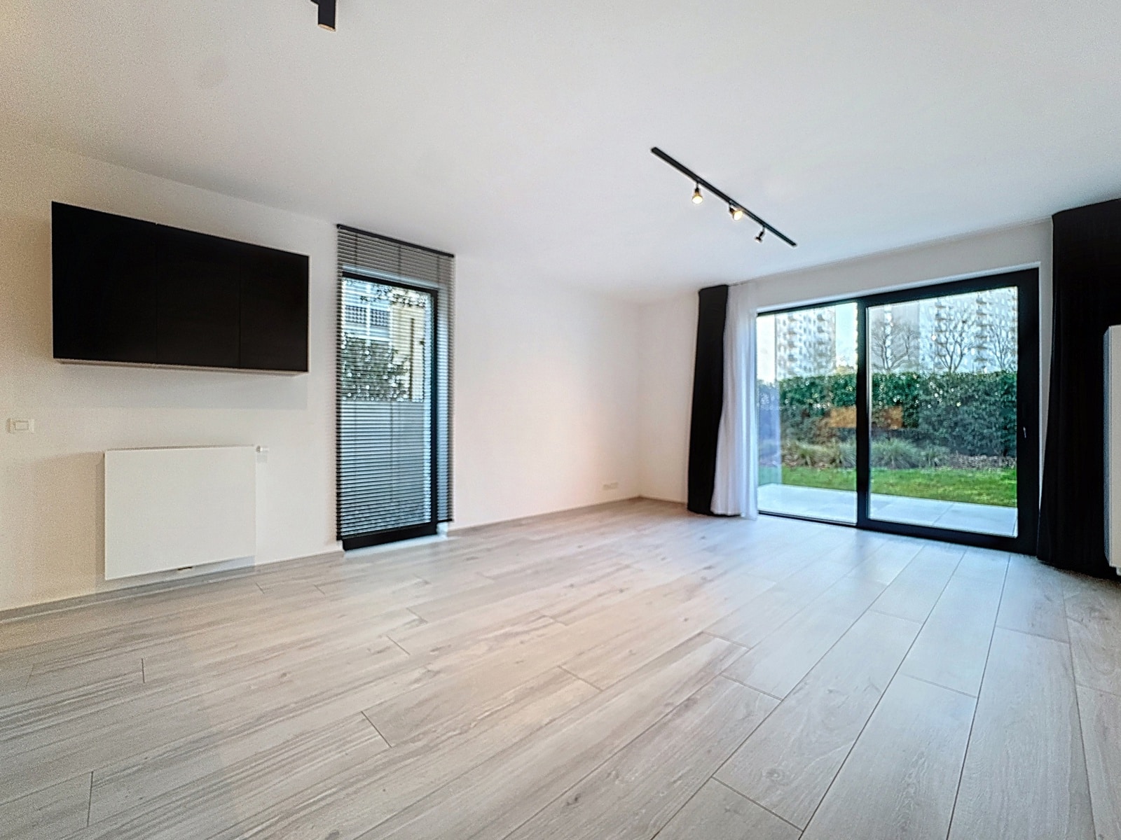Salon Lumineux avec Baies Vitrées – You Real Estate Agency Salon moderne lumineux avec baies vitrées, parquet clair et accès terrasse