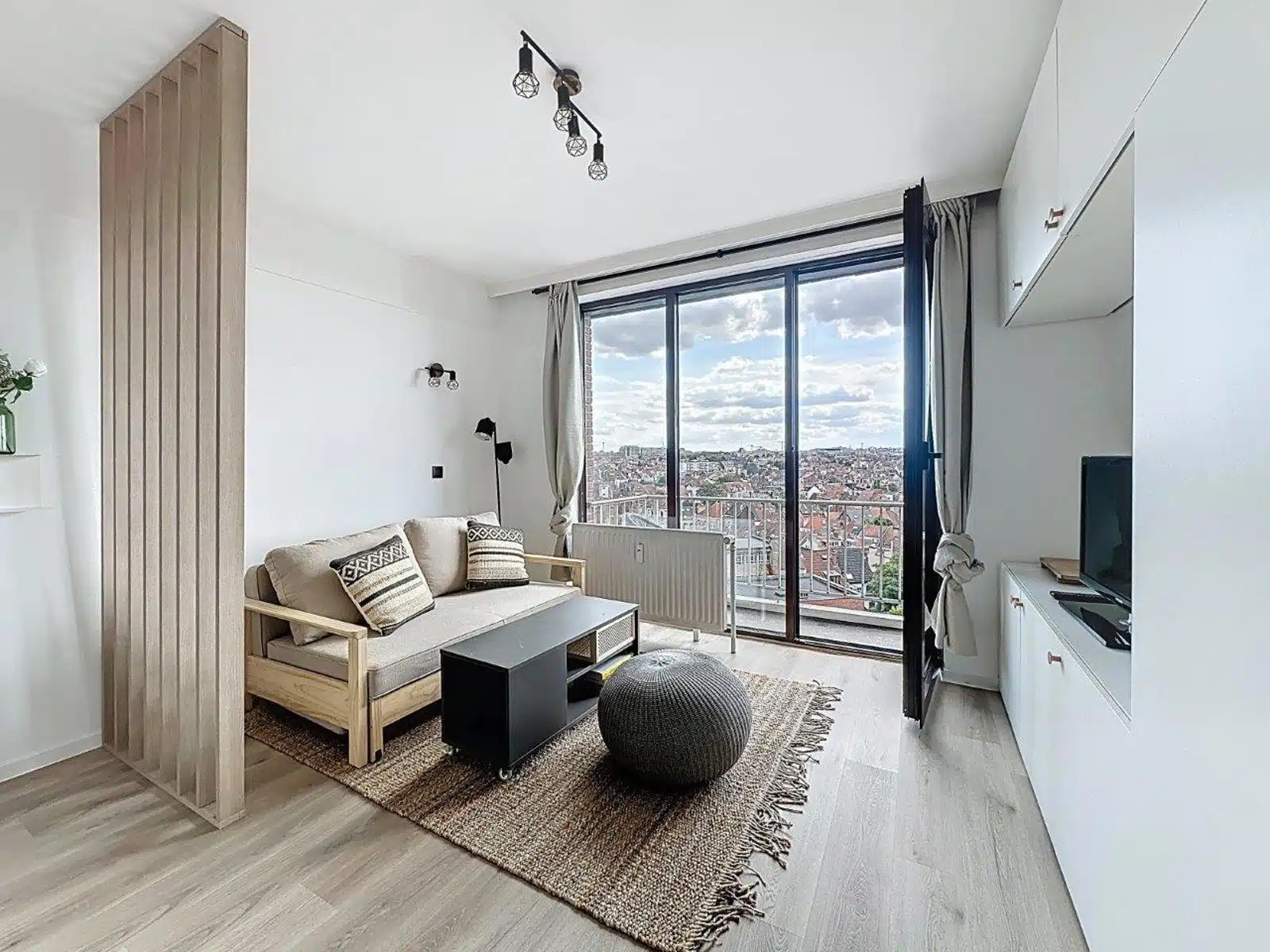 Bright Living Room with Urban View - You Real Estate Agency Bright, modern apartment living room with balcony, urban view and light parquet flooring.
