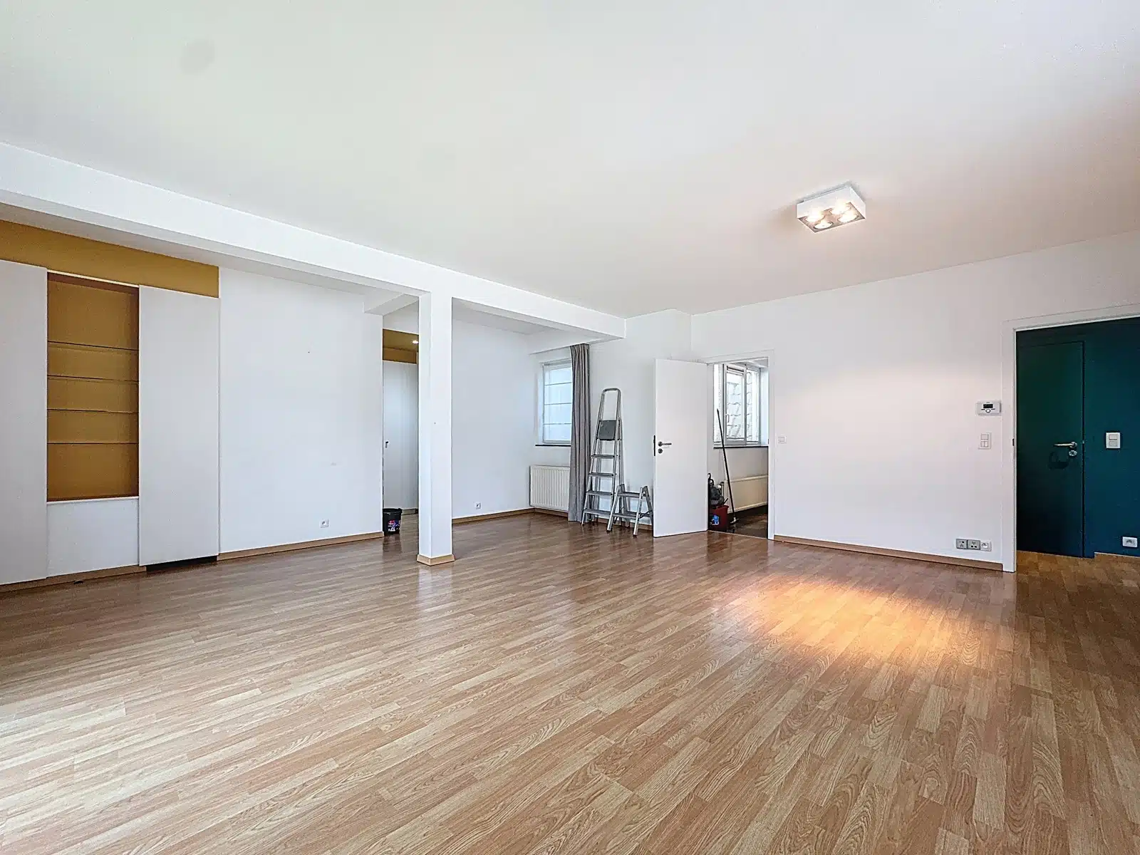 Salon Lumineux avec Parquet – You Real Estate Agency Salon lumineux d’appartement vide avec parquet et travaux en cours.