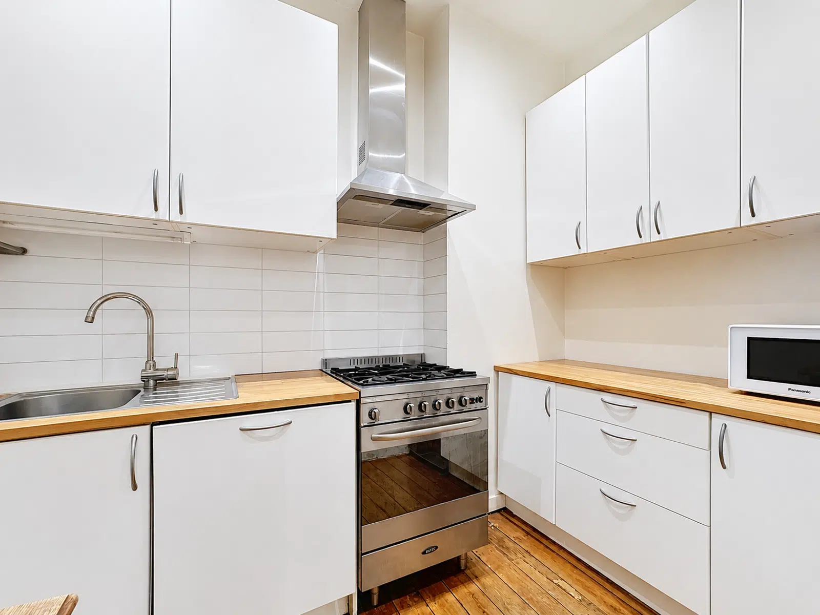 Cuisine Moderne Equipée - You Real Estate Agency Cuisine équipée moderne avec plans de travail en bois et électroménagers inox.