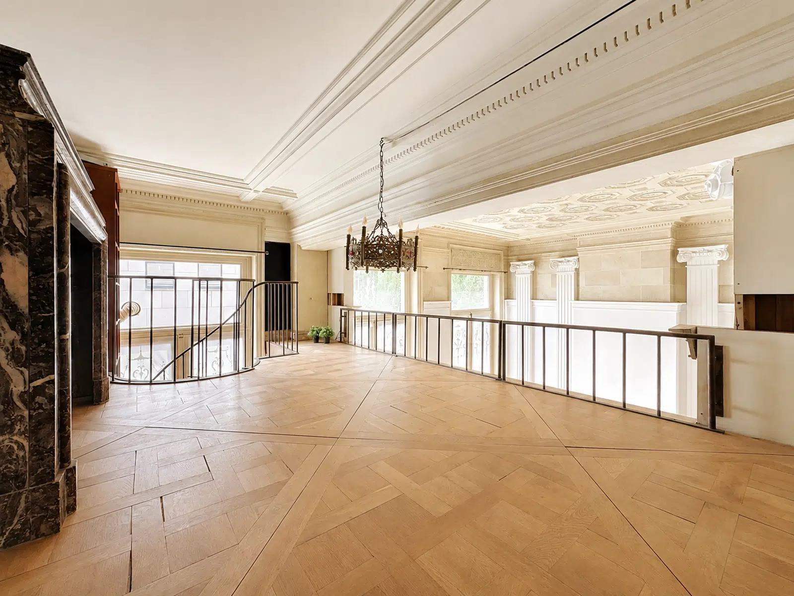 Mezzanine Élégante avec Colonnes – You Real Estate Agency Mezzanine élégante avec parquet, cheminée en marbre et colonnes dans appartement de prestige.