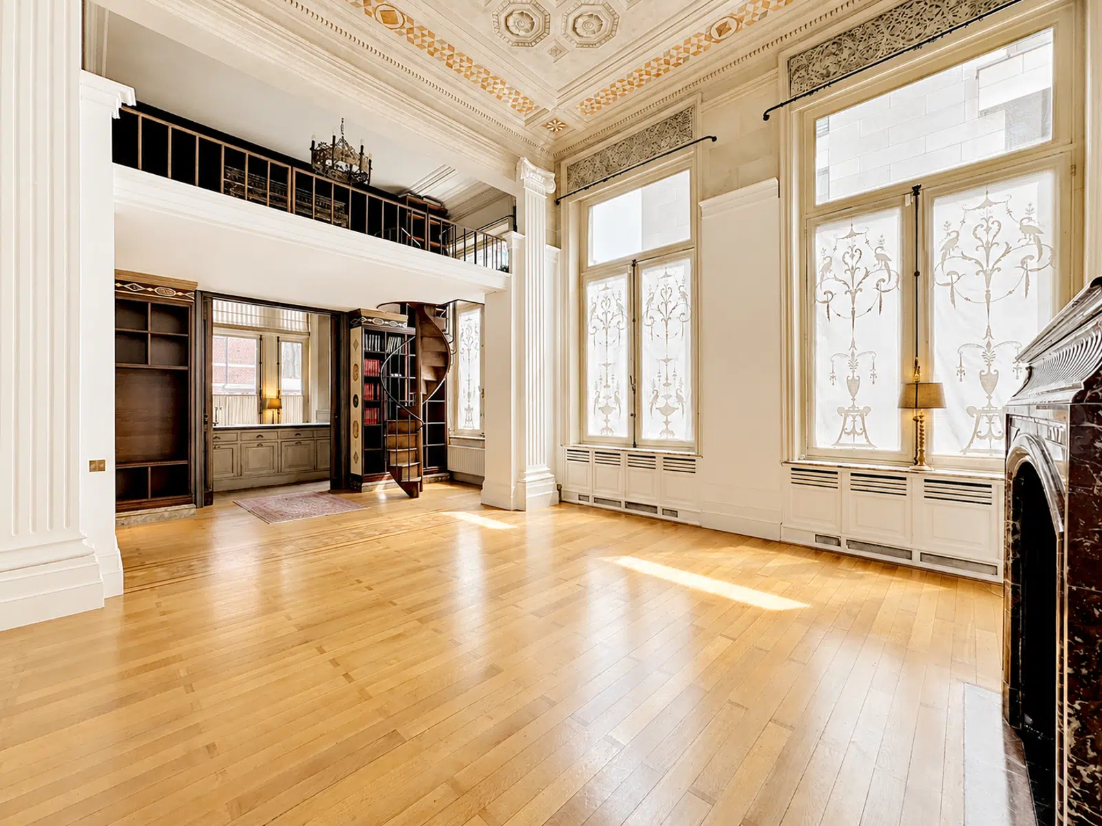 Salon Bibliothèque avec Mezzanine – You Real Estate Agency Salon bibliothèque luxueux avec mezzanine, parquet et hauts plafonds dans appartement de caractère.