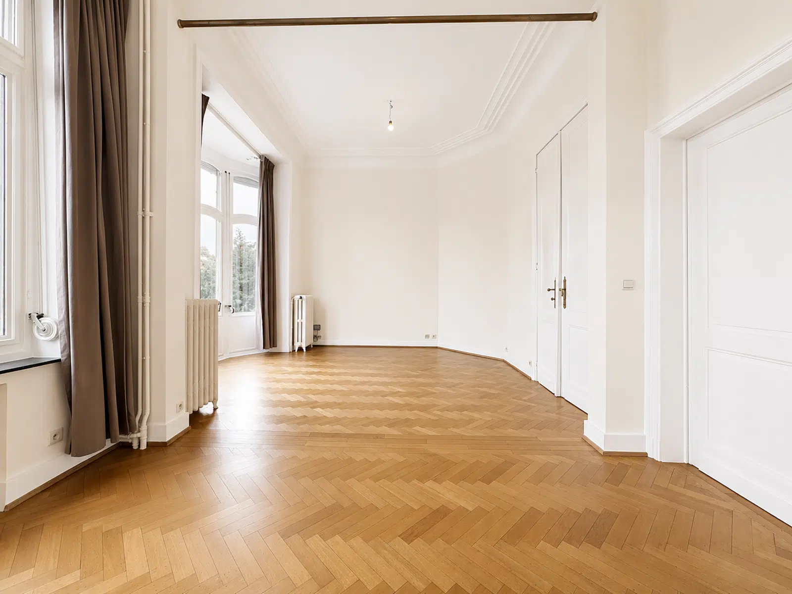 Salon Lumineux avec Parquet – You Real Estate Agency Salon lumineux d’appartement ancien avec parquet en chevrons, moulures et grandes fenêtres.