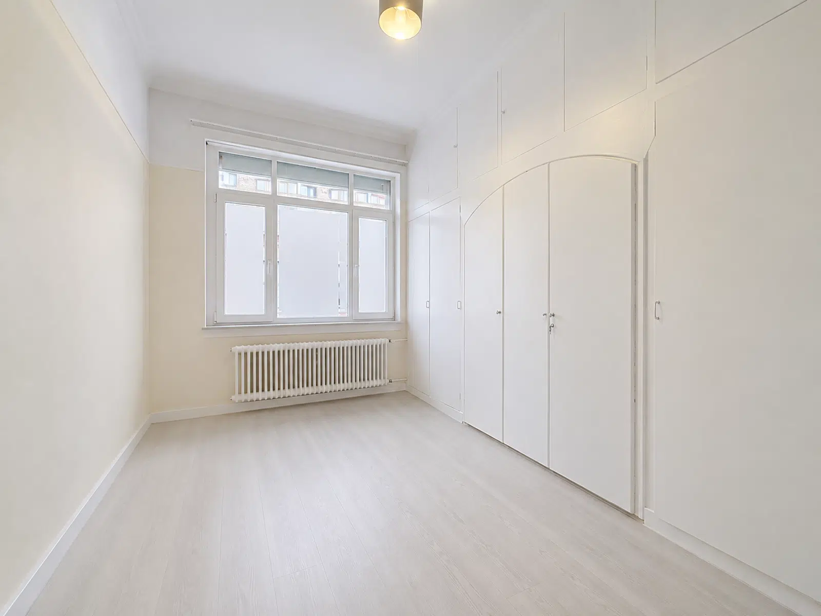 Bright room with built-in closets - You Real Estate Agency Bright room with built-in cupboards and light parquet flooring in renovated apartment.