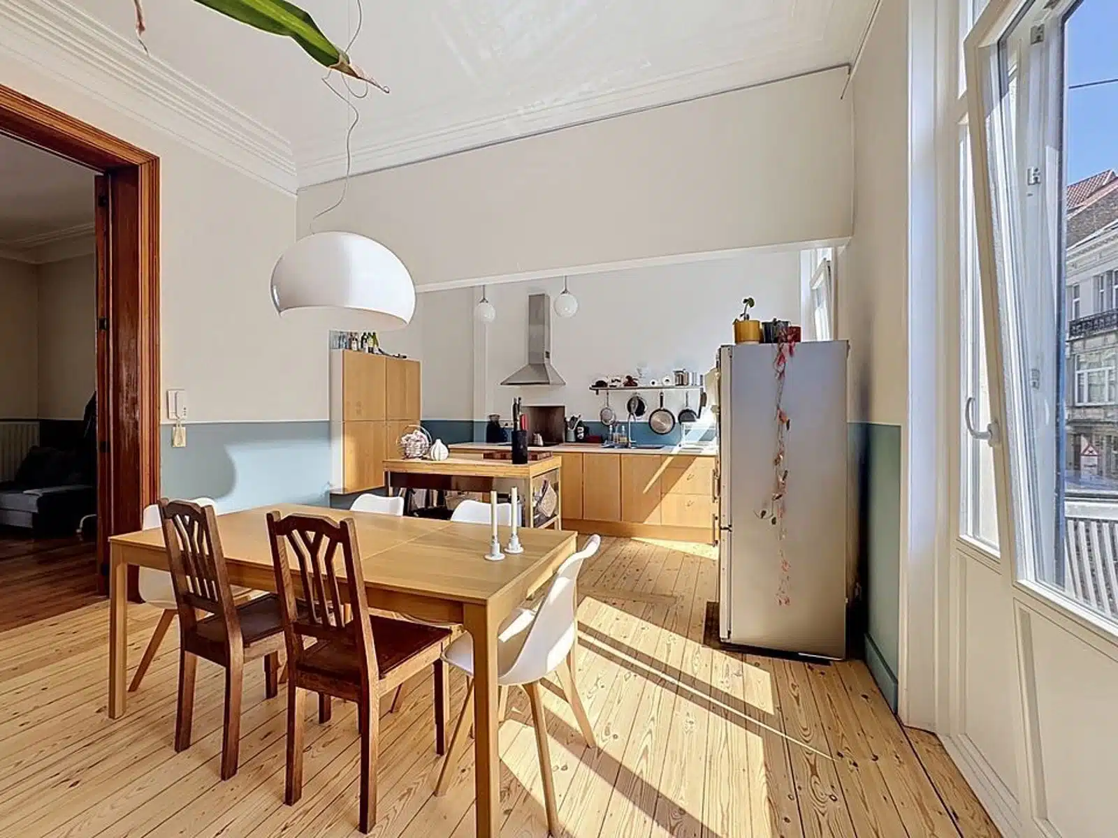 Lichte keuken met eetkamer - You Real Estate Agency Lichte open keuken en eetkamer in oude flat met parketvloer.