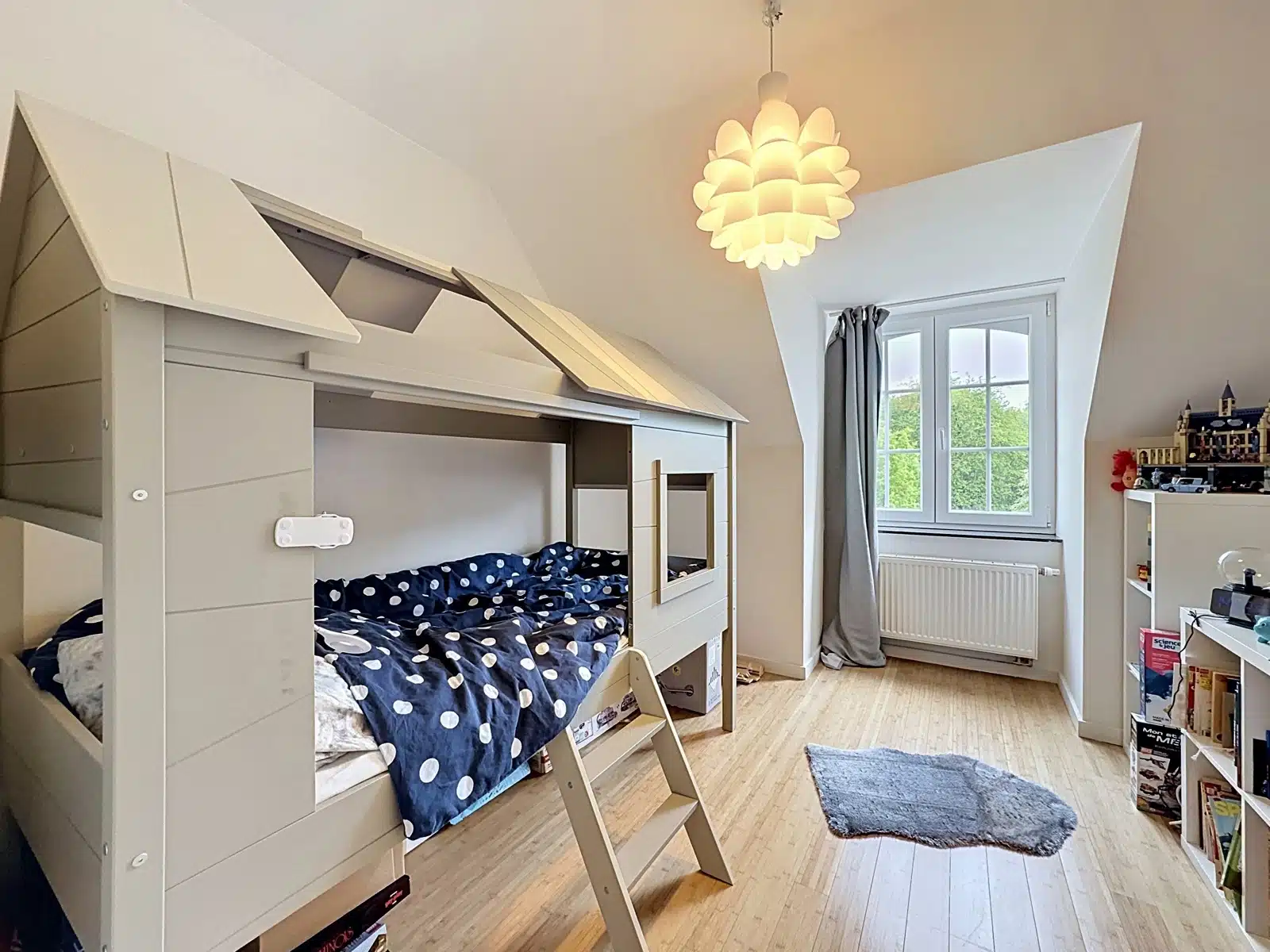 whise photo 7 White house-shaped loft bed with ladder in a bright kids' room; navy polka-dot bedding visible on the lower bunk.