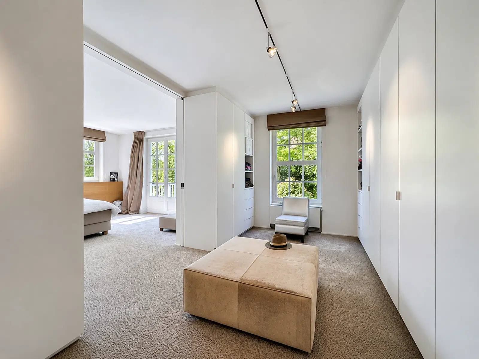 Suite Parentale avec Dressing – You Real Estate Agency Chambre avec dressing intégré et coin nuit lumineux dans un appartement moderne.