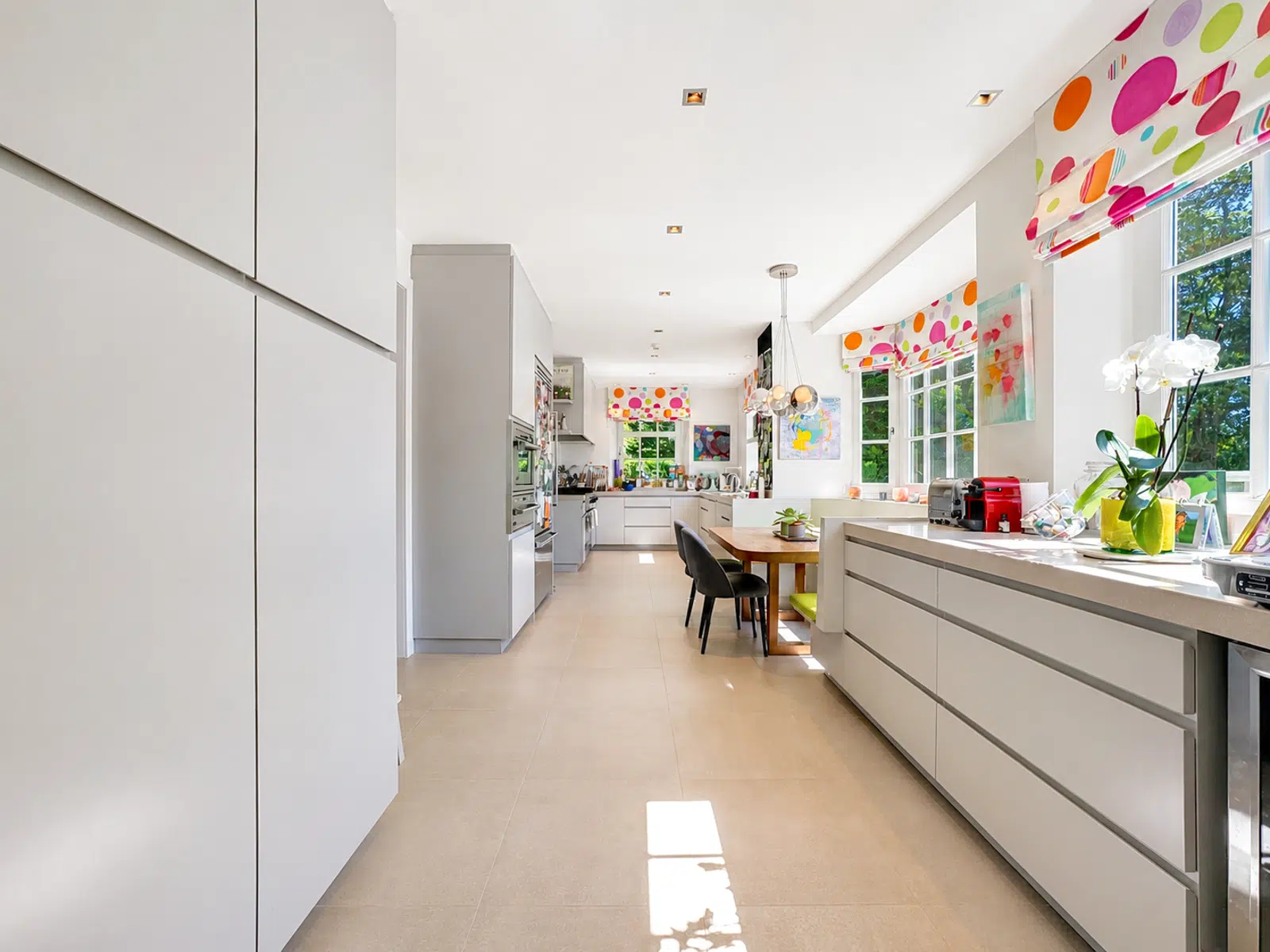 Cuisine Moderne Lumineuse – You Real Estate Agency Cuisine moderne lumineuse avec rangements intégrés, coin repas et grandes fenêtres.