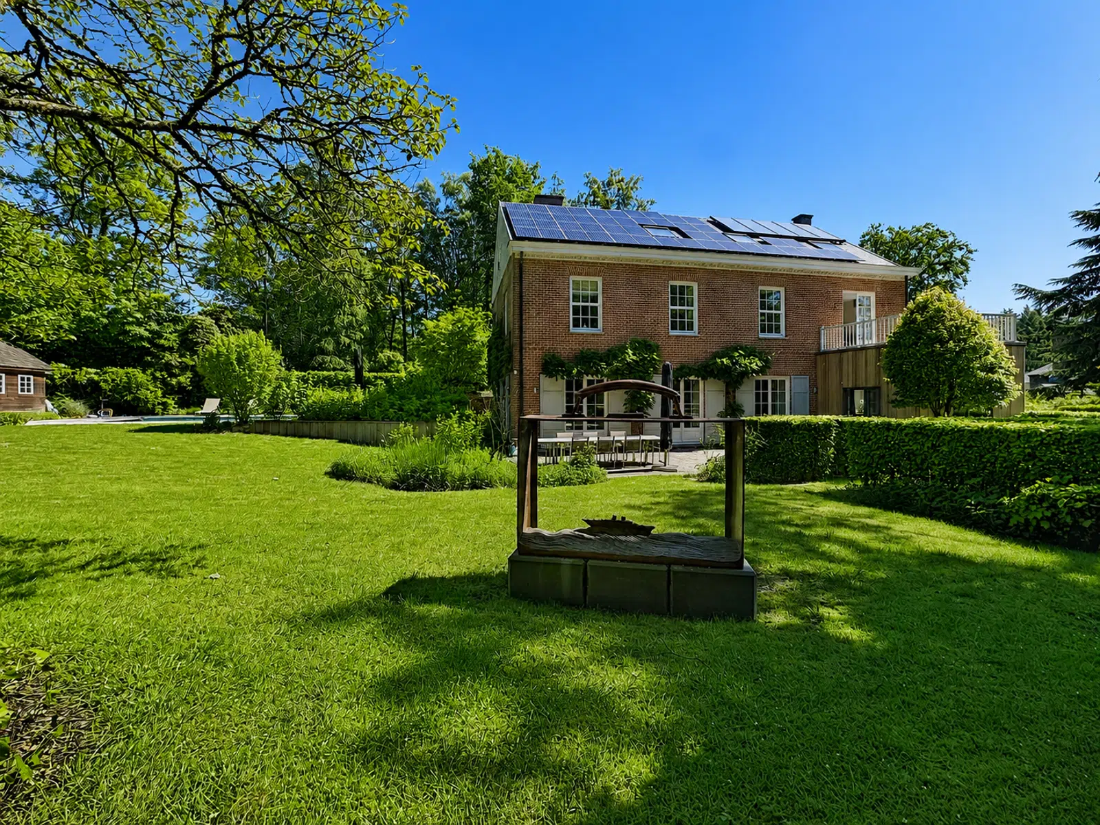 Jardin avec Maison à Panneaux Solaires – You Real Estate Agency Maison en briques avec jardin paysager, terrasse et panneaux solaires.