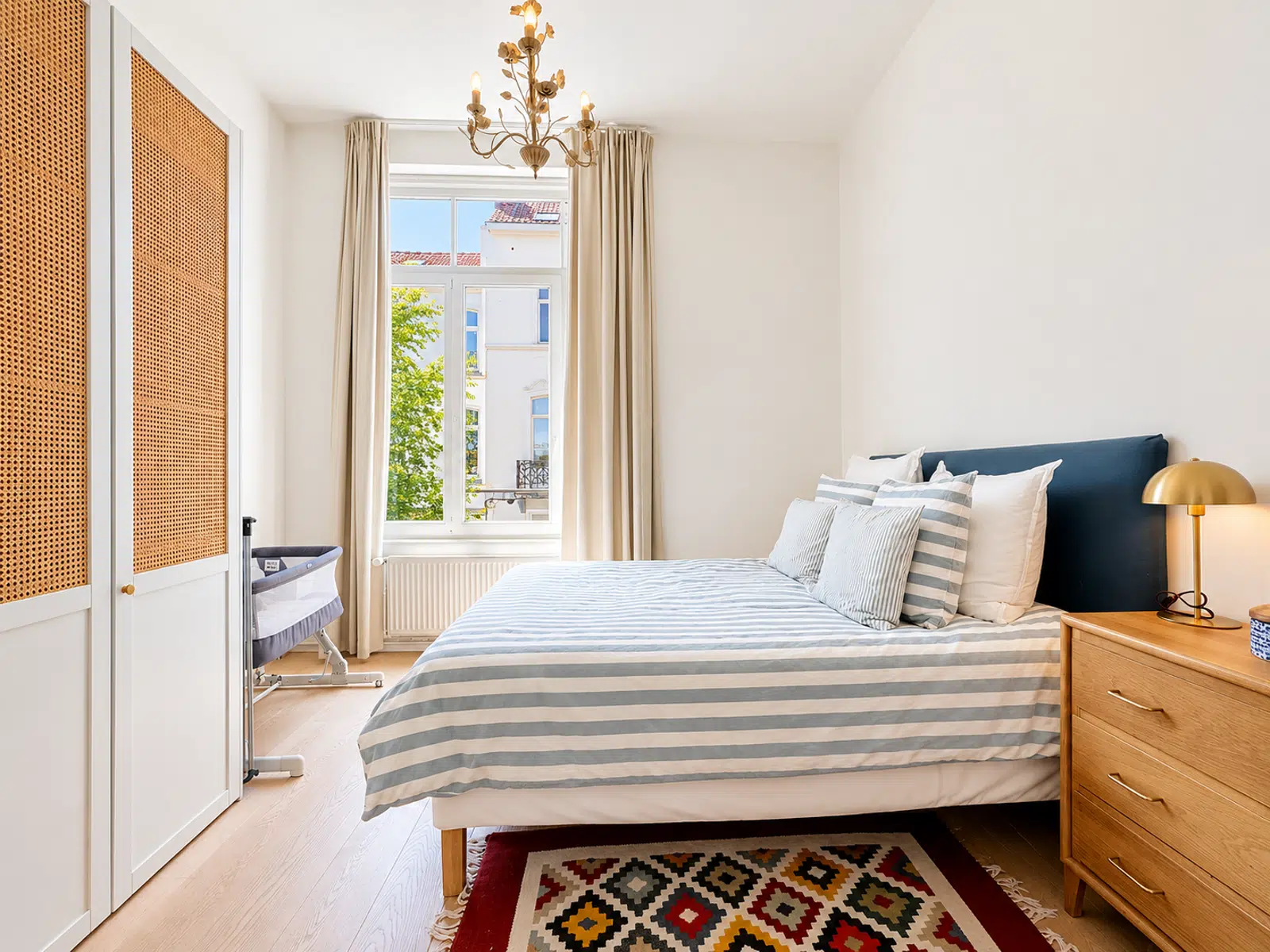 Chambre Lumineuse avec Parquet Clair – You Real Estate Agency Chambre lumineuse d’appartement avec lit double, dressing et parquet clair.