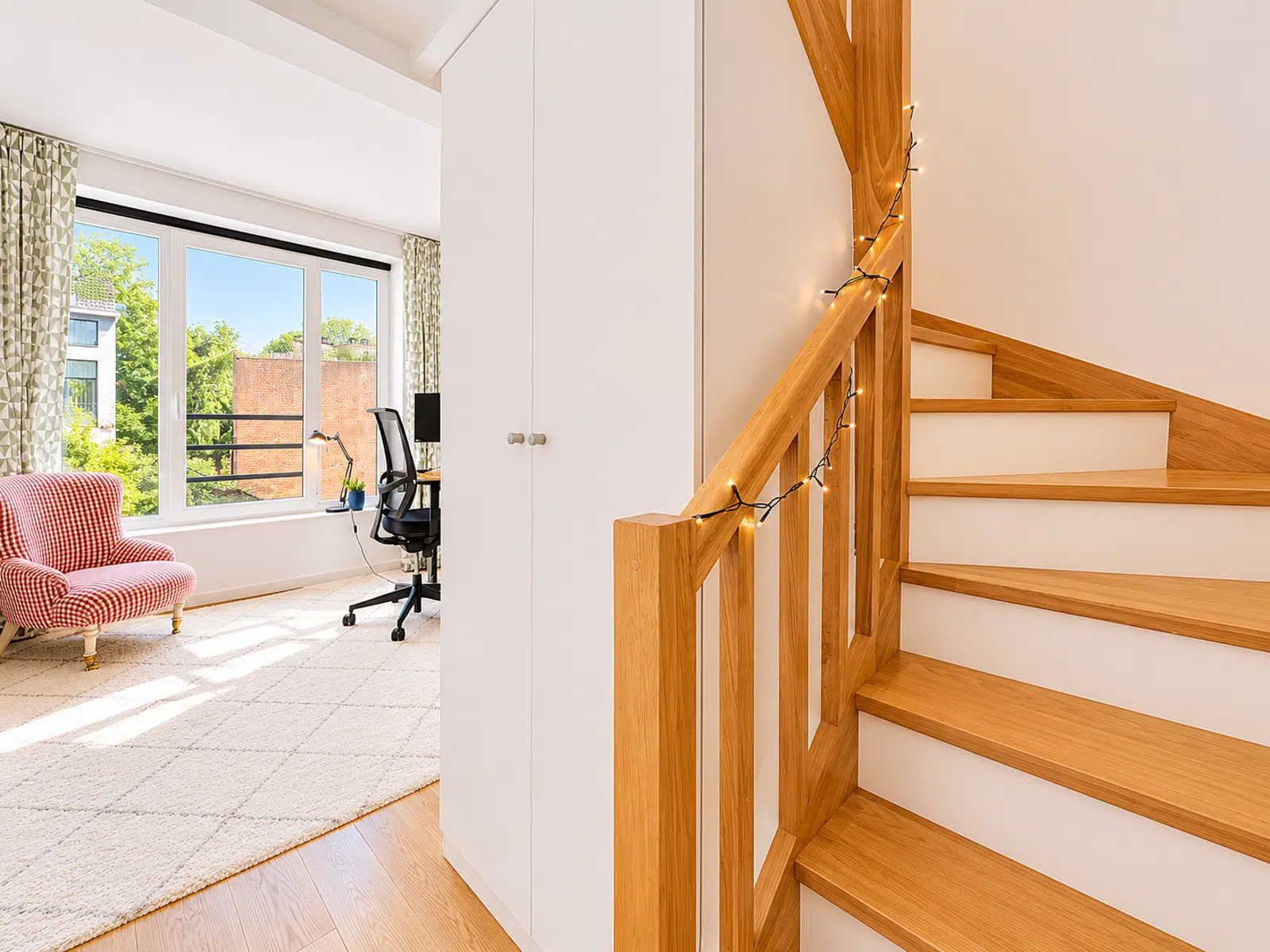 Espace Bureau Lumineux avec Escalier – You Real Estate Agency Appartement lumineux avec salon, coin bureau, escalier en bois et grandes fenêtres.