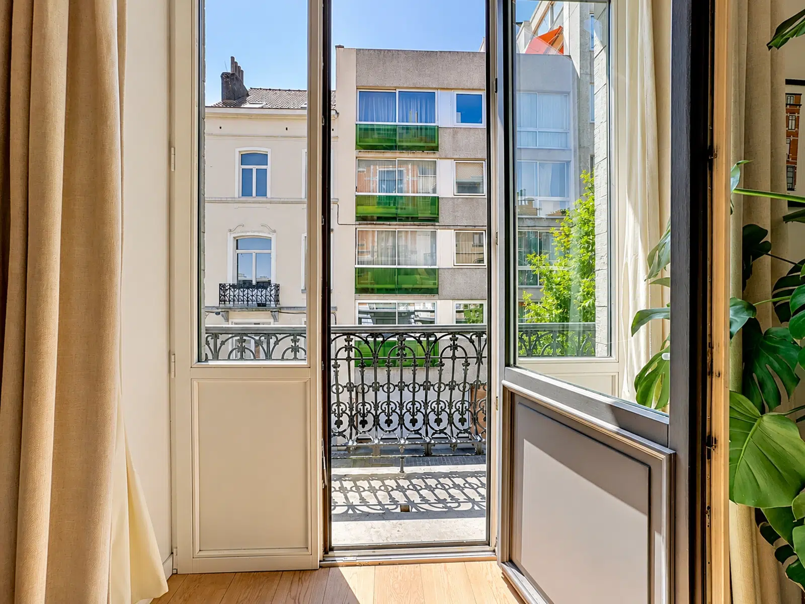 Balcon Ensoleillé avec Vue Urbaine – You Real Estate Agency Appartement lumineux avec balcon en fer forgé et vue urbaine.