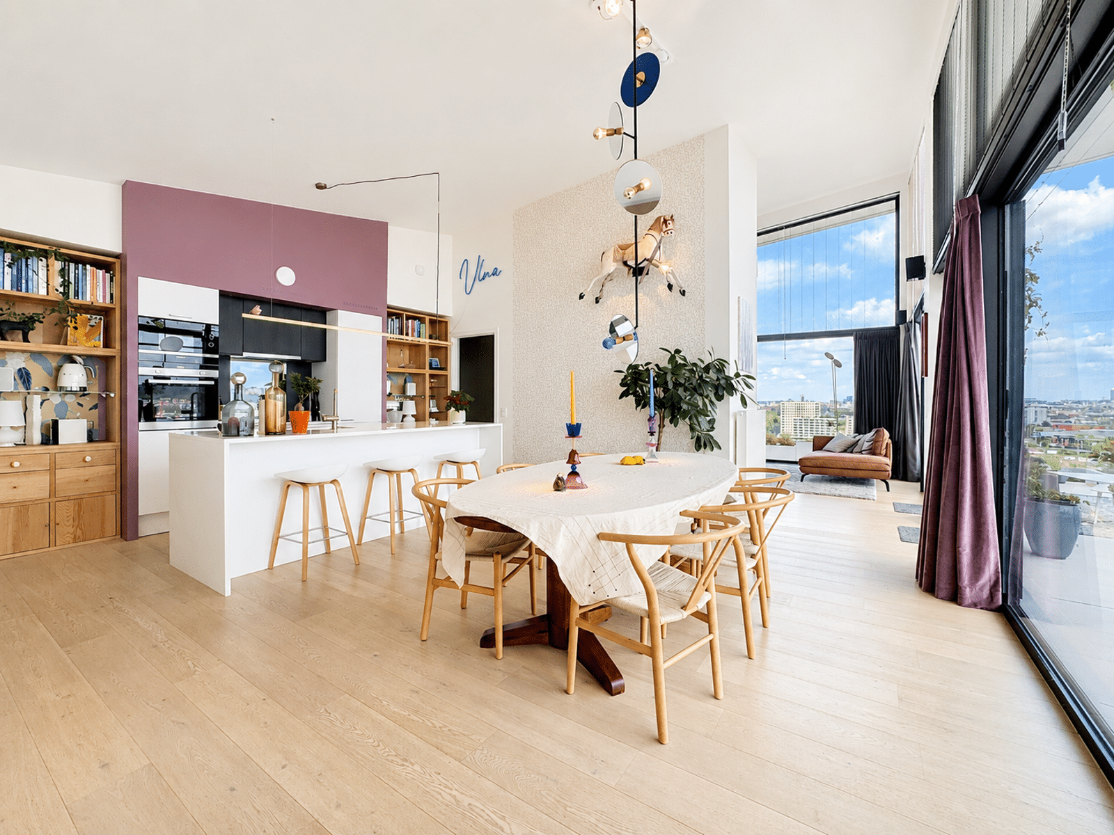 Séjour Lumineux avec Cuisine Ouverte – You Real Estate Agency Appartement lumineux avec cuisine ouverte, salle à manger et salon avec vue urbaine.