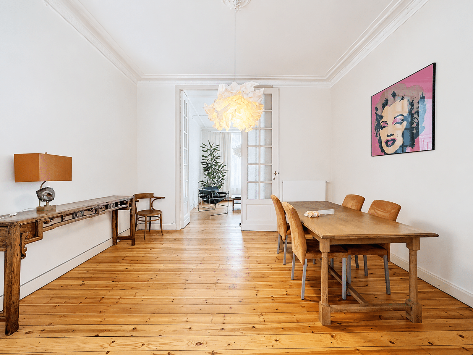 Elegante eetkamer - Uw Makelaarskantoor Lichte eetkamer met parketvloer en houten tafel in elegante flat.
