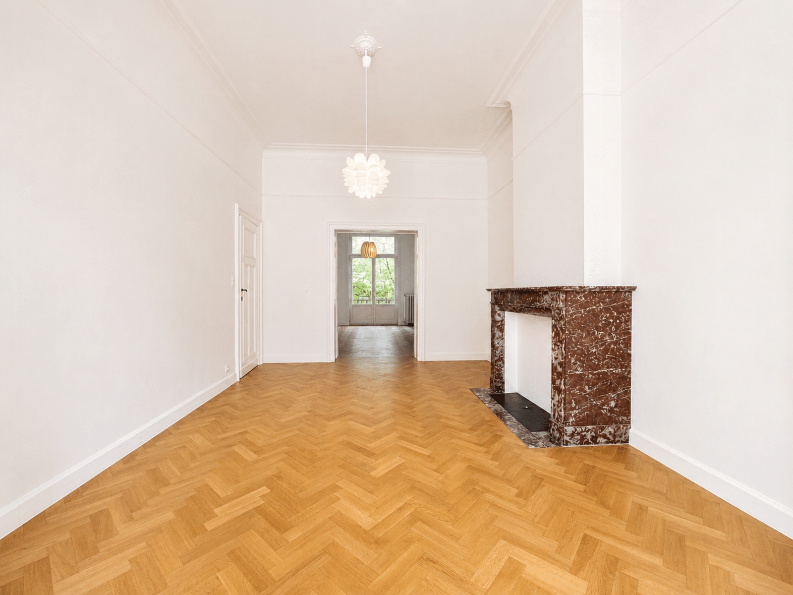Bright Living Room With Parquet - You Real Estate Agency Salon lumineux d’appartement avec parquet en chevrons et cheminée décorative.