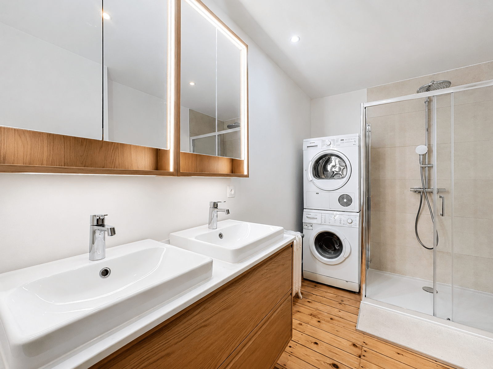 Bathroom with double basin - You Real Estate Agency Salle de bain moderne avec double vasque, douche vitrée et buanderie en appartement.