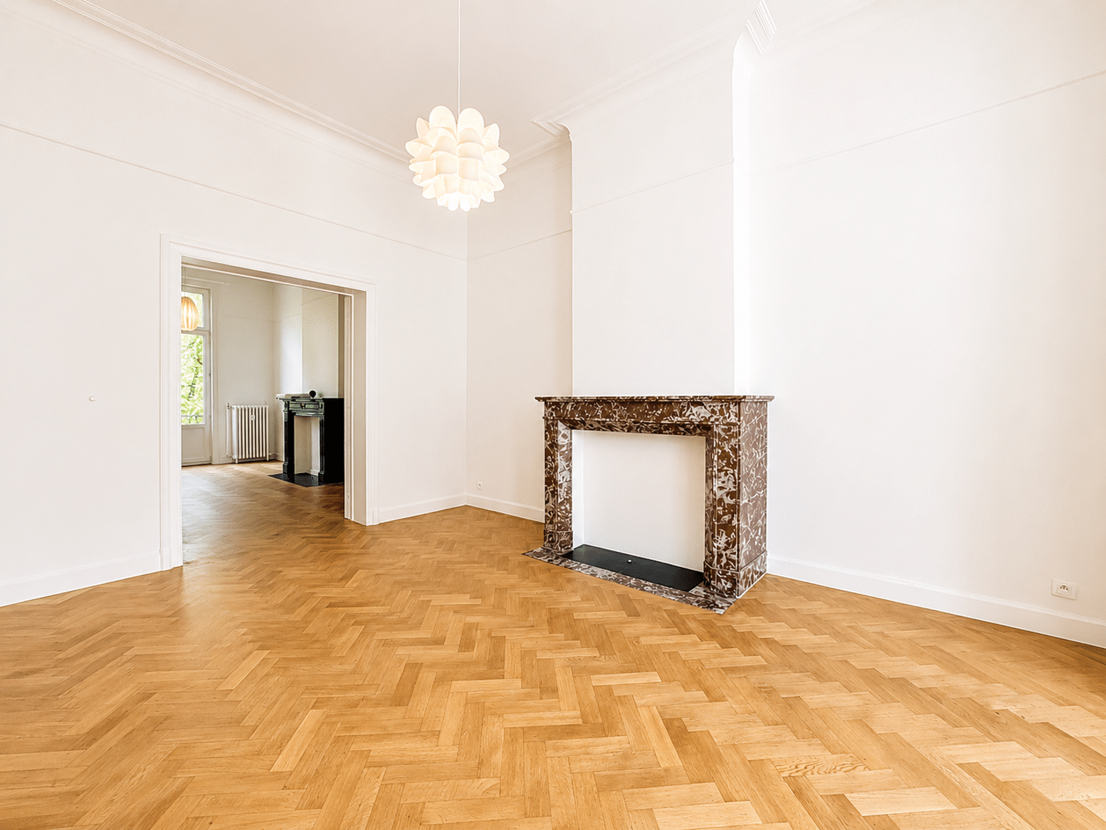 Salon avec Cheminée en Marbre – You Real Estate Agency Salon lumineux avec parquet en point de Hongrie et cheminée en marbre.