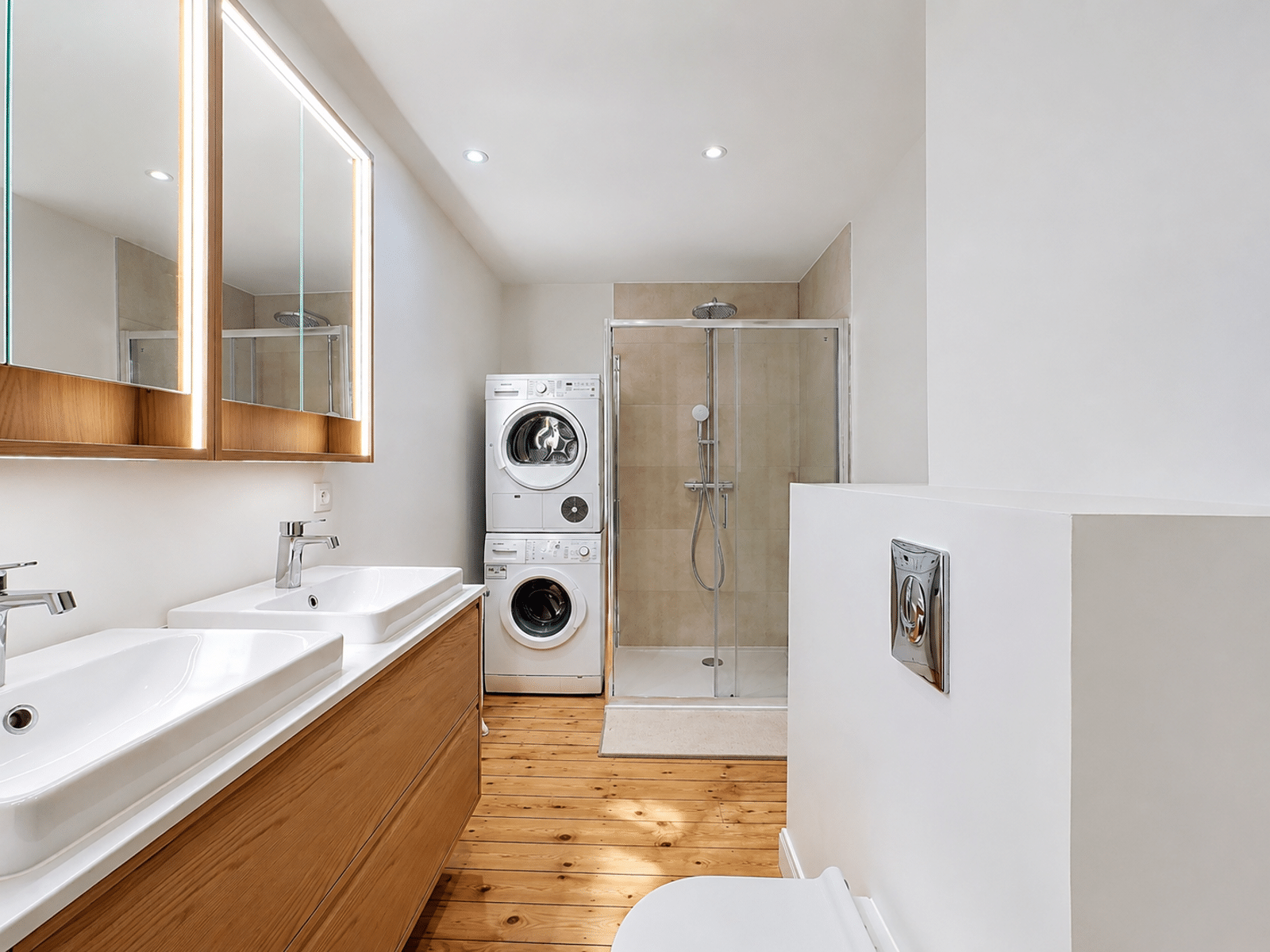 Salle de Bain Moderne avec Buanderie – You Real Estate Agency Salle de bain moderne avec double vasque, douche vitrée et buanderie en appartement.