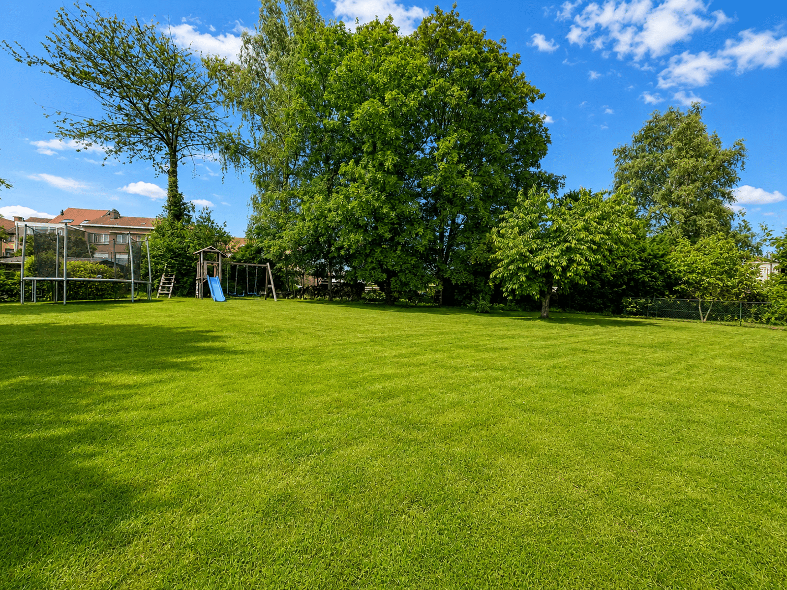 Jardin Verdoyant Avec Aire De Jeux - You Real Estate Agency Large green garden with playground for family home.