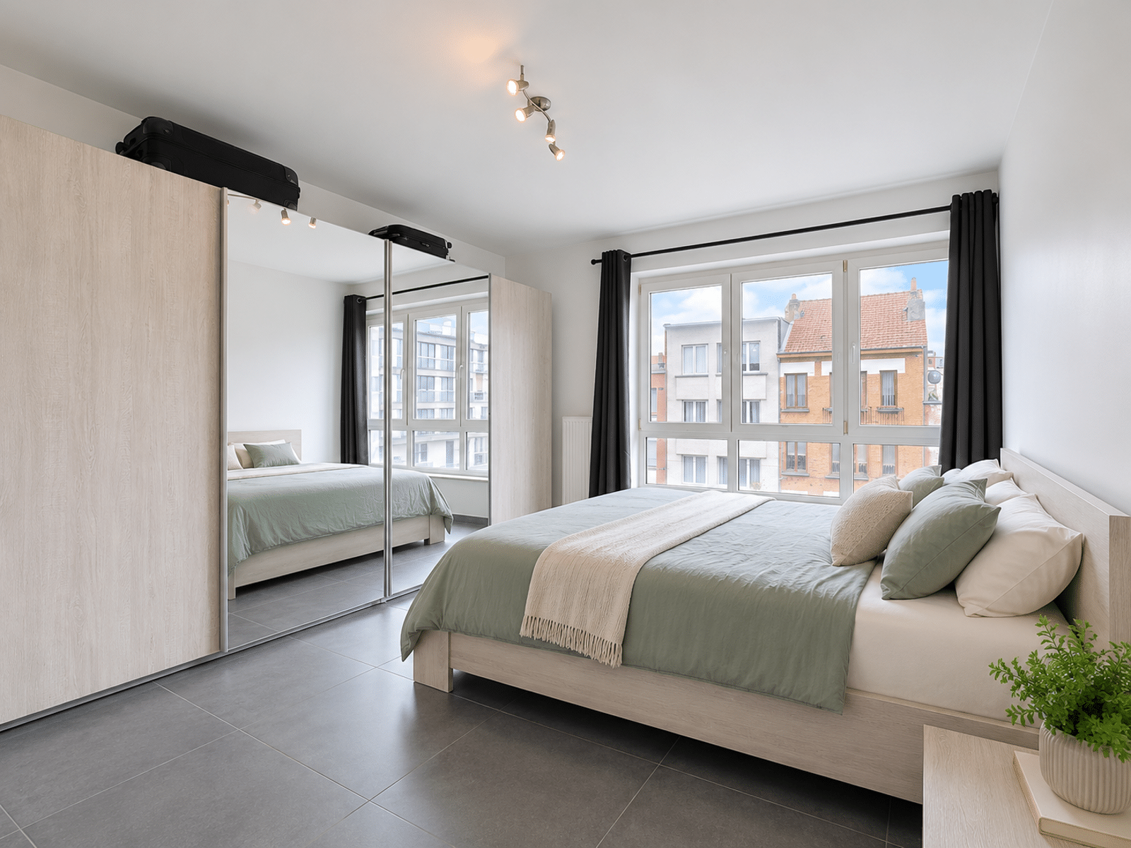 Bright bedroom with mirrored dressing room - You Real Estate Agency Bright apartment bedroom with wooden bed, large window and mirrored dressing room.