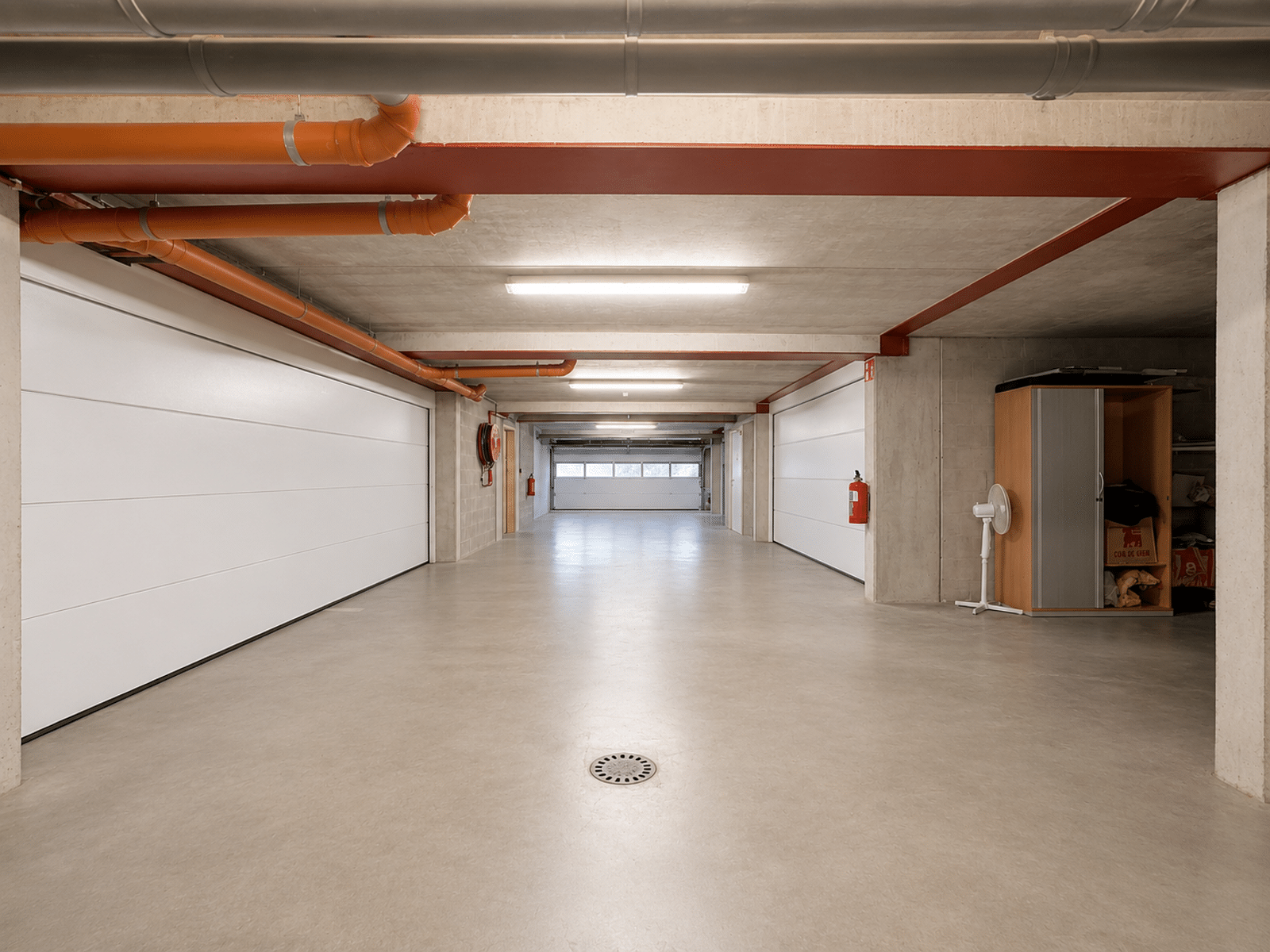 Indoor basement garage - You Real Estate Agency Spacious basement garage with sectional doors and storage space.
